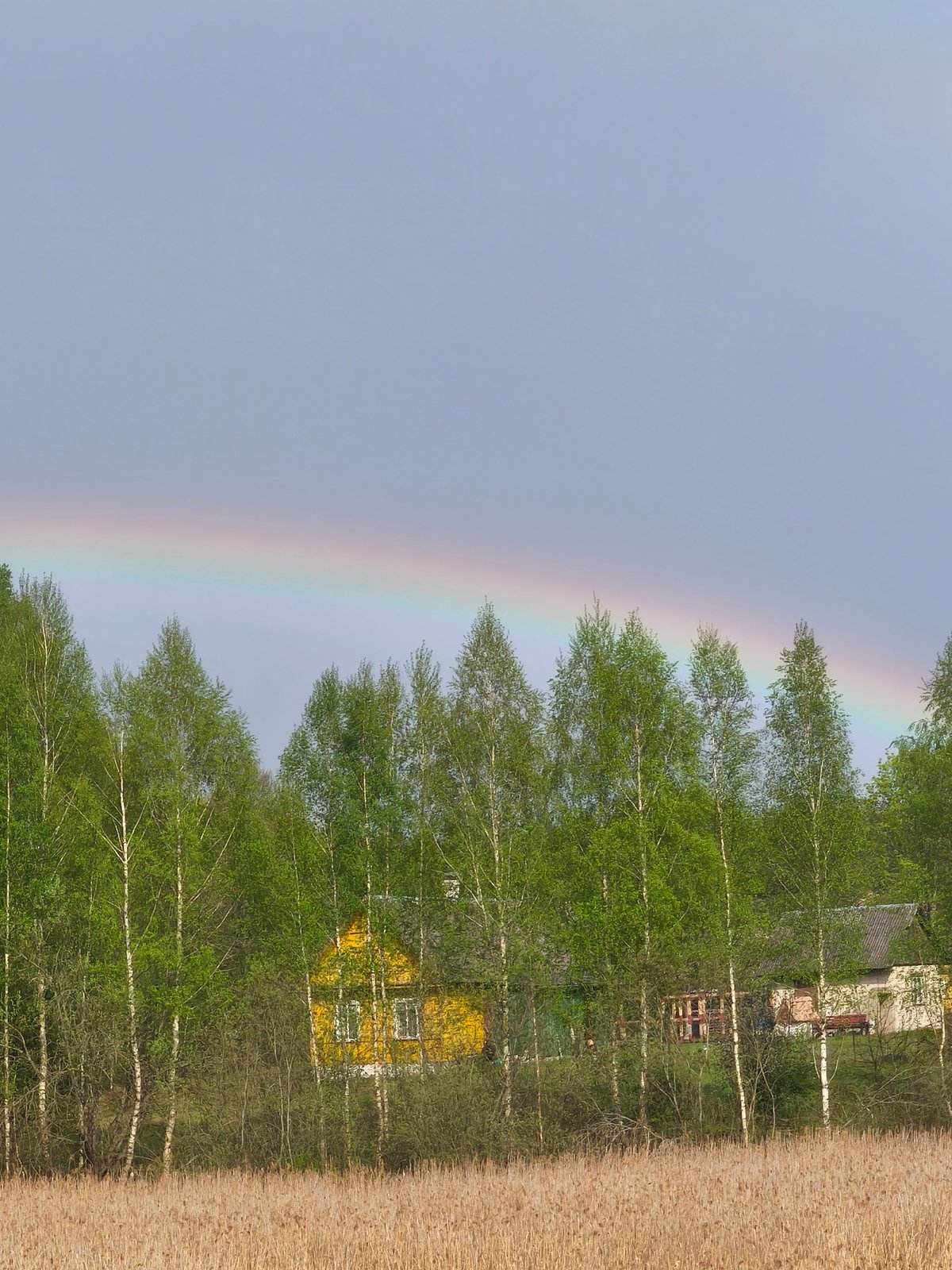 Rainbow appears over rural Belarus countryside