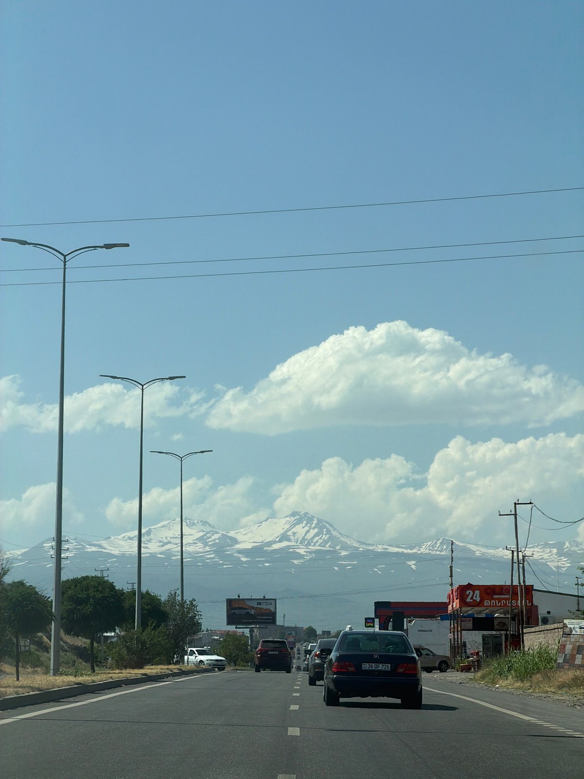 Road through Proshyan with snow-capped Armenian mountains behind