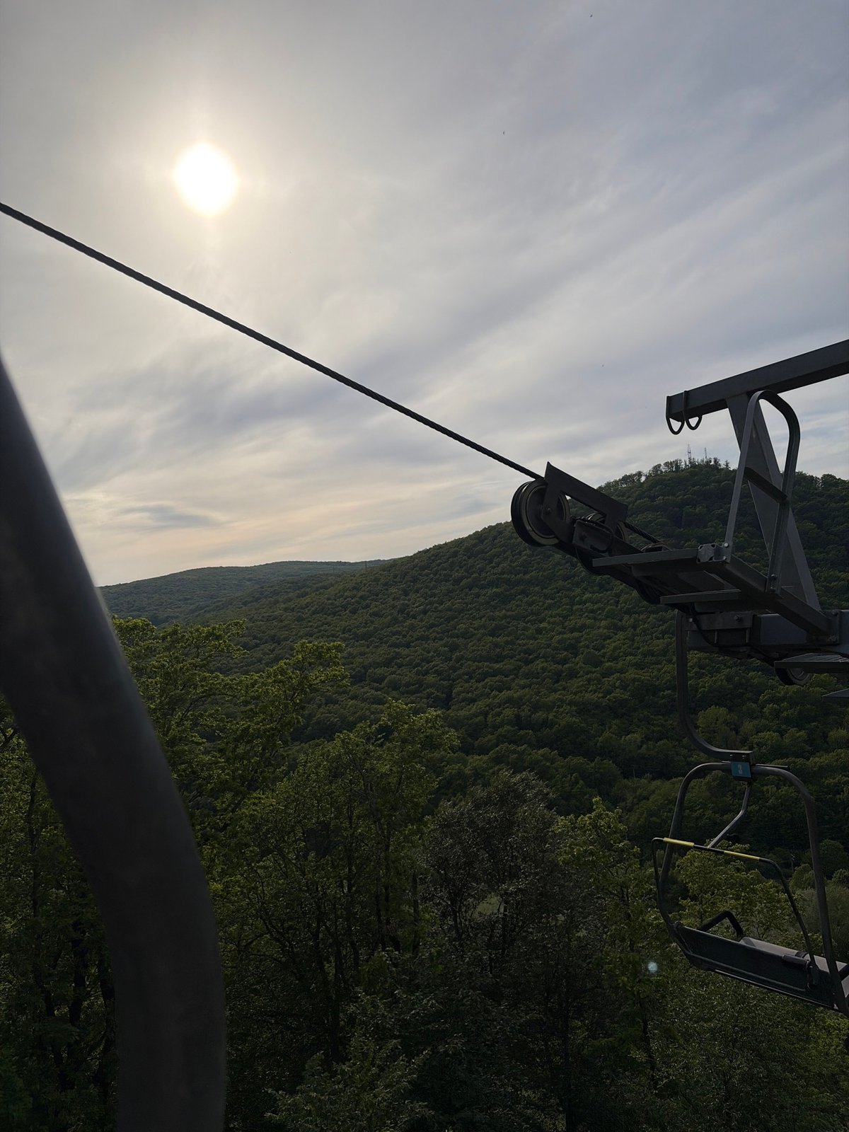 Chairlift operates over wooded mountains in Goryachiy Klyuch, Russia