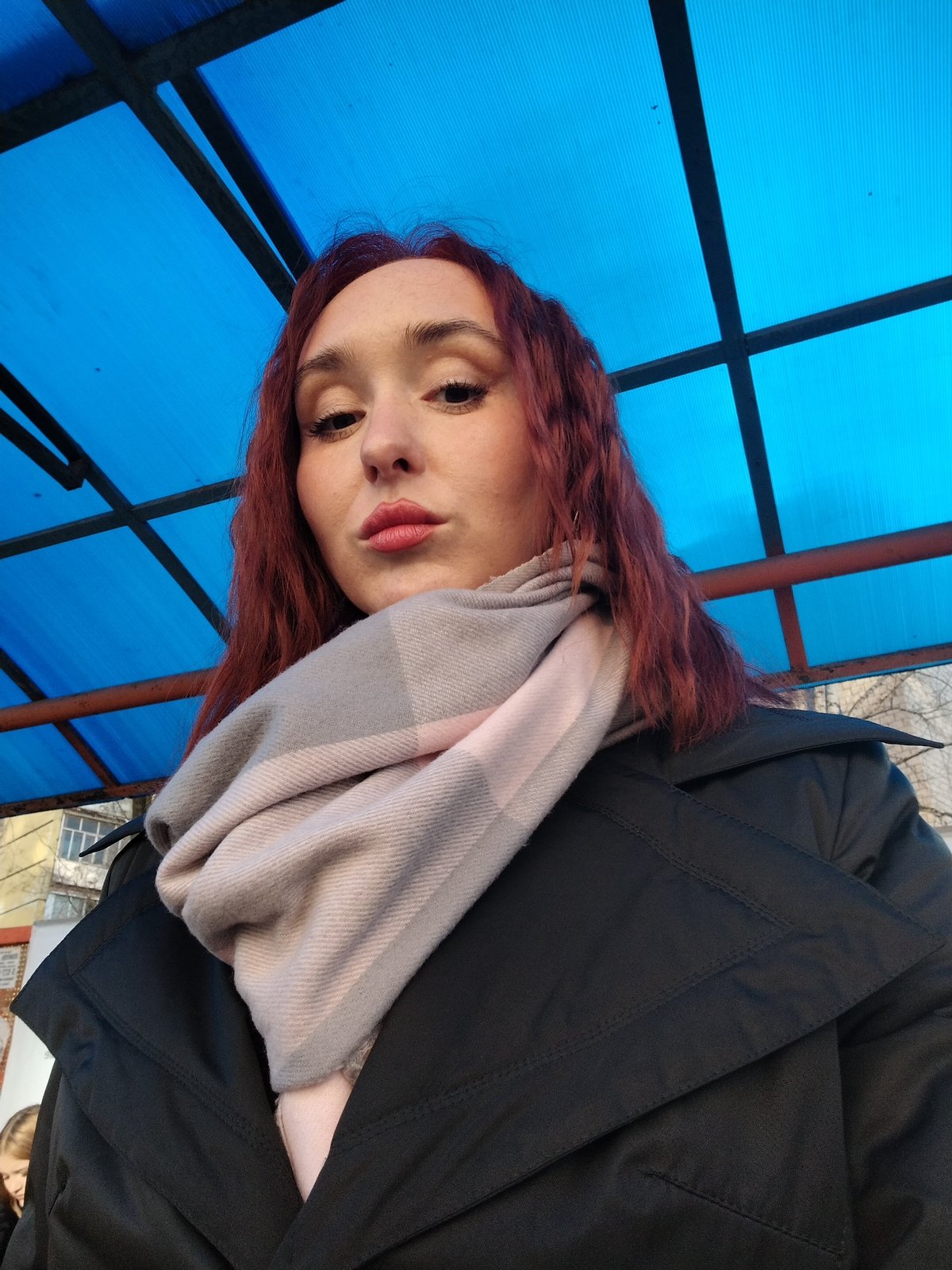 Woman in black coat observed under roof in Izhevsk