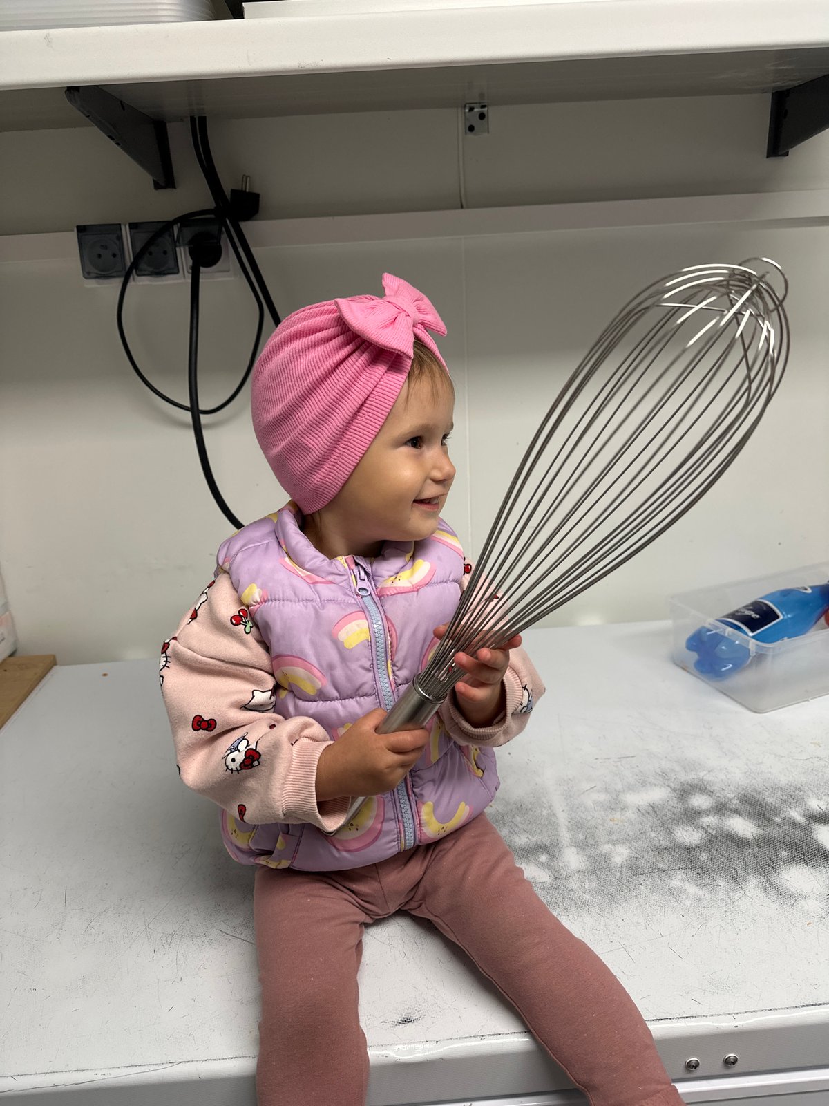 Toddler in pink hat plays indoors in Wisła, Poland