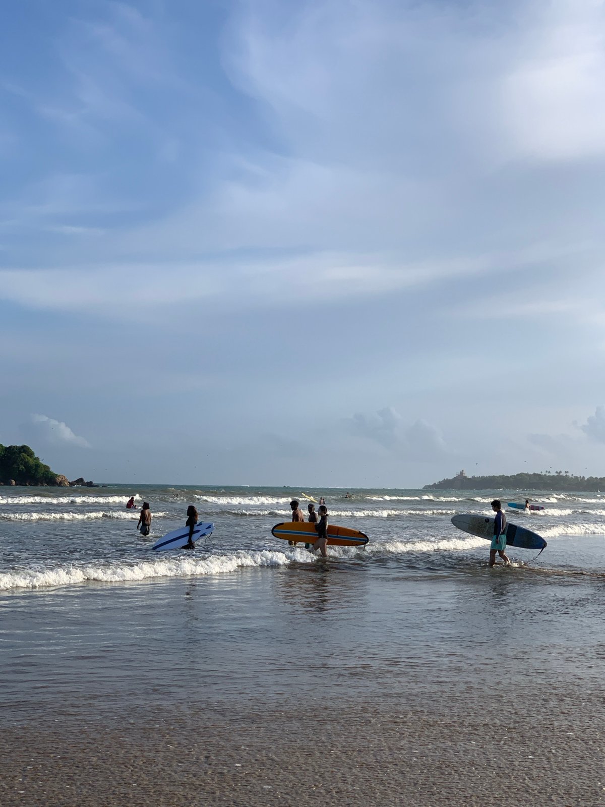 Busy morning surf session and beach activities in Weligama