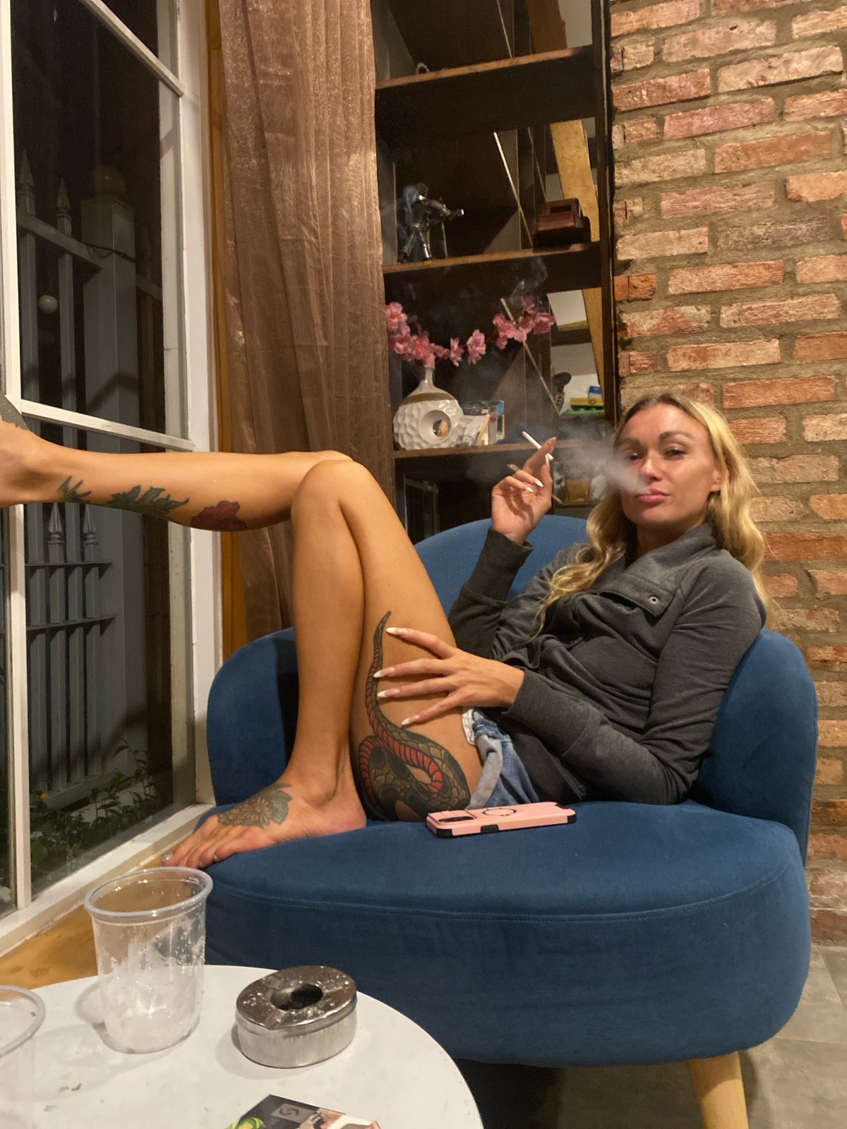 Chilling on blue furniture in a Da Lat room, tattoos and all