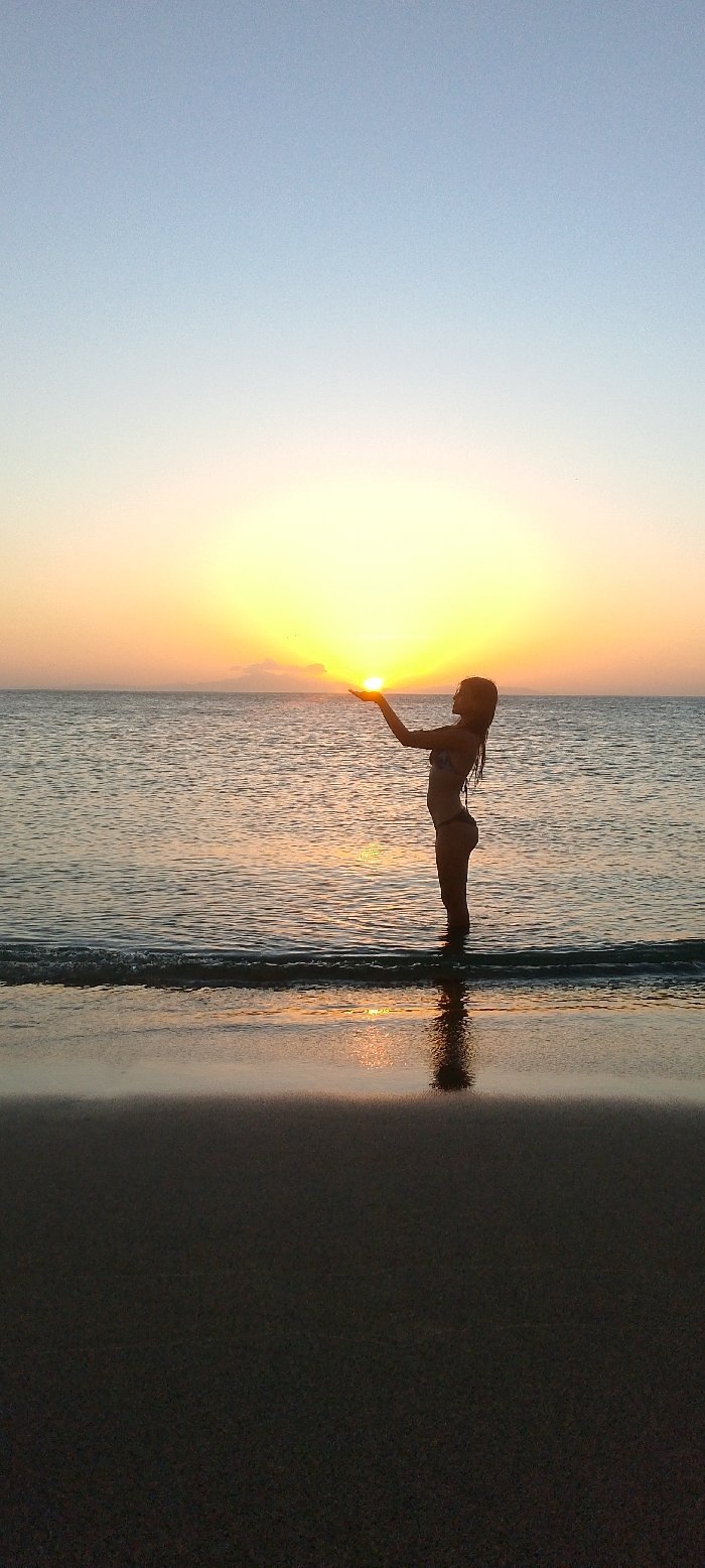 Woman poses with sunset at Juan Griego beach
