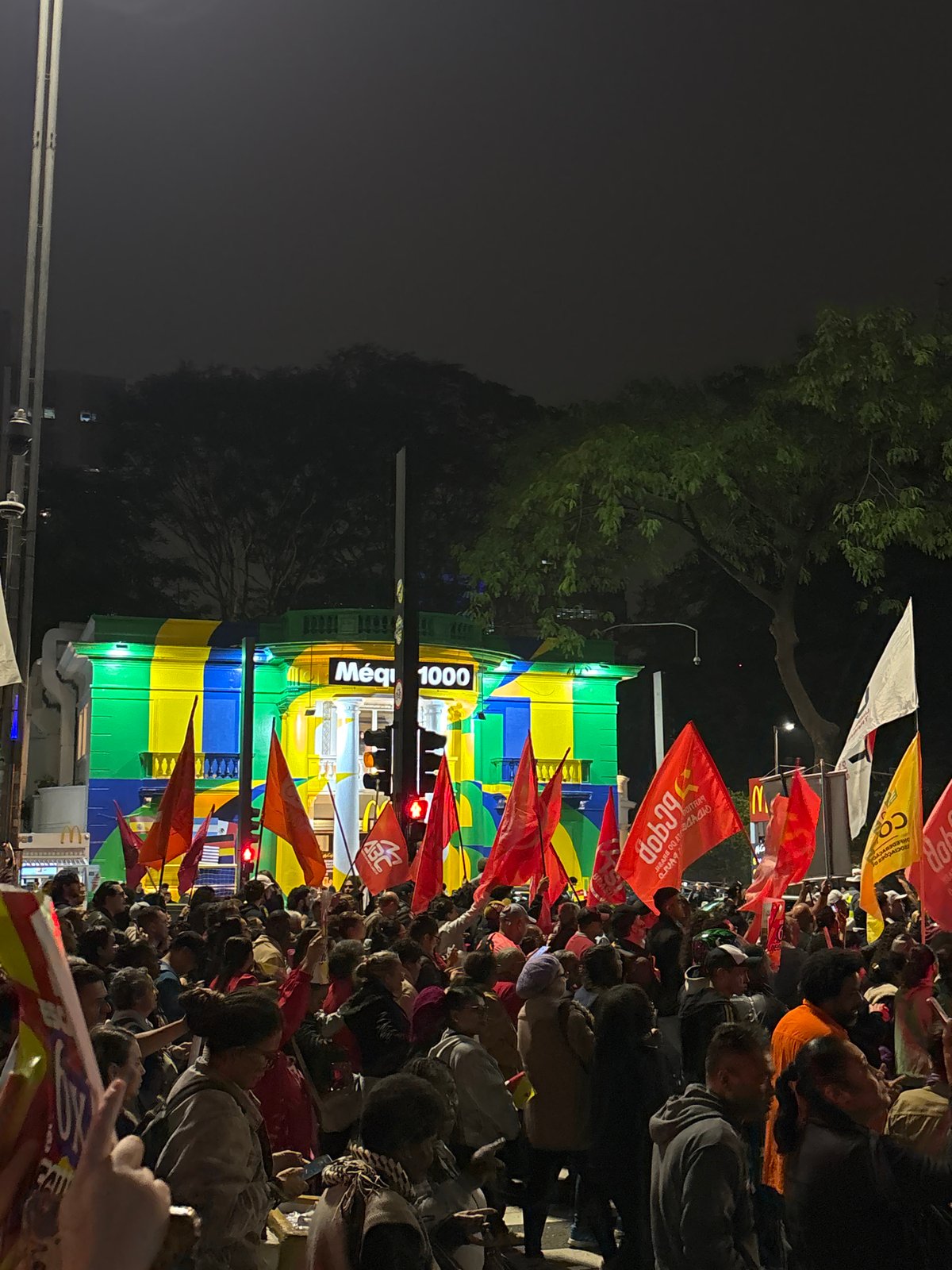 Flag-carrying crowds demonstrate in nighttime São Paulo streets
