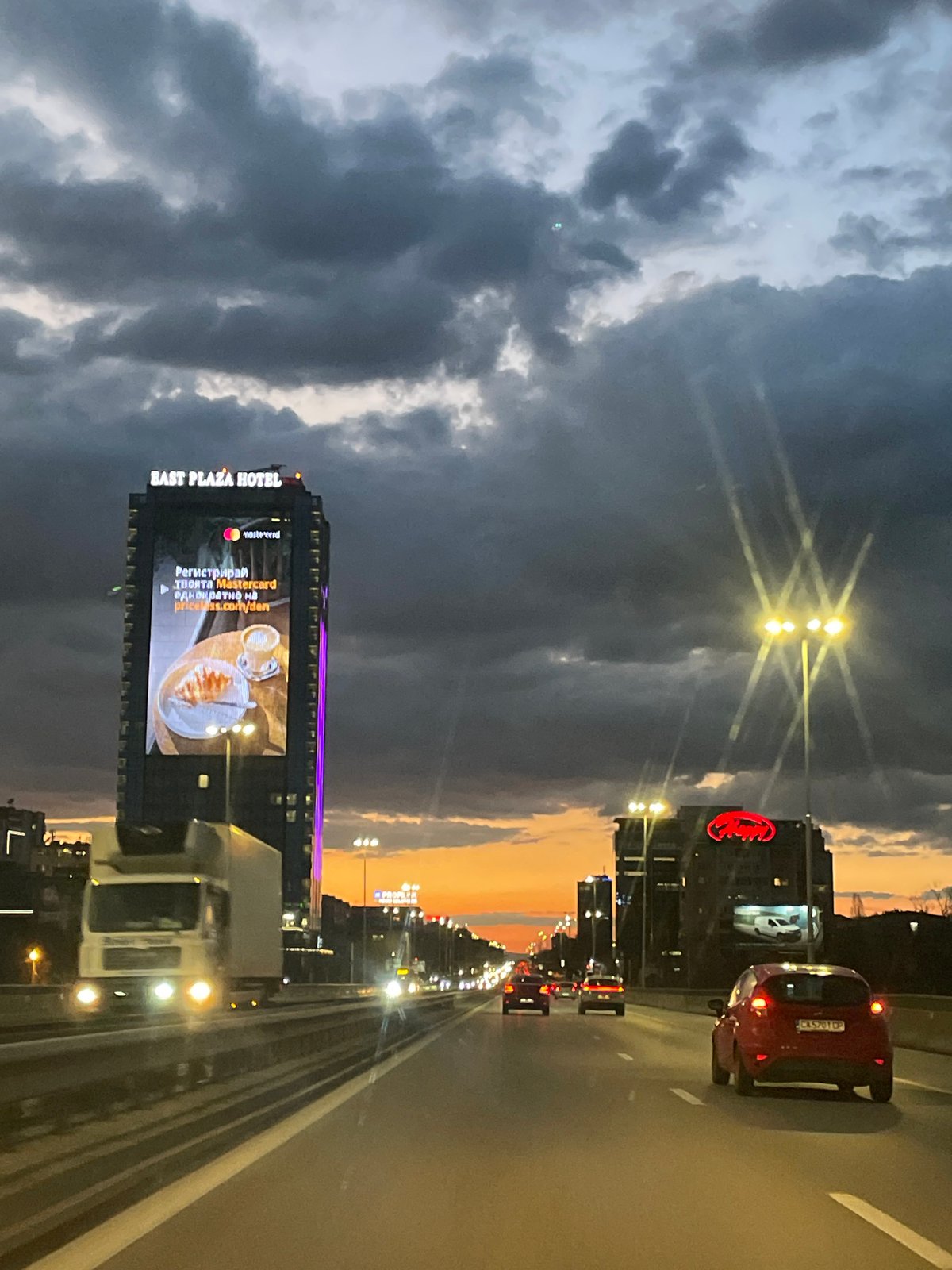 Highway approach to Sofia captured at dusk with dramatic clouds