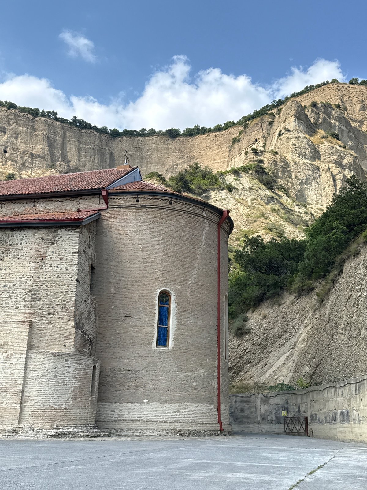 Ancient monastery nestled beneath rocky cliffs in Dzegvi, Georgia