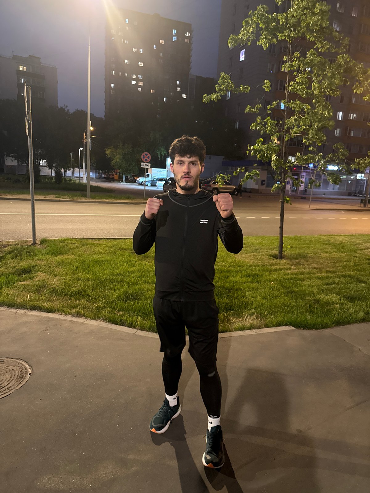 Man in athletic wear observed with clenched fists on Moscow sidewalk