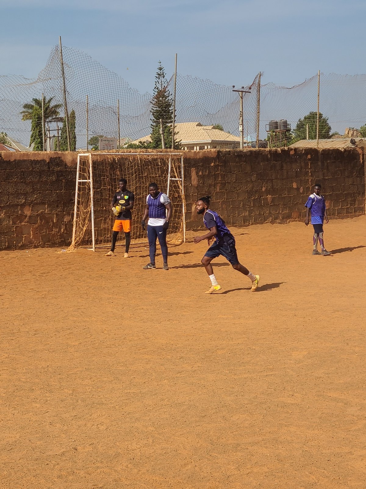 Morning soccer match on dirt field in Nigerian village