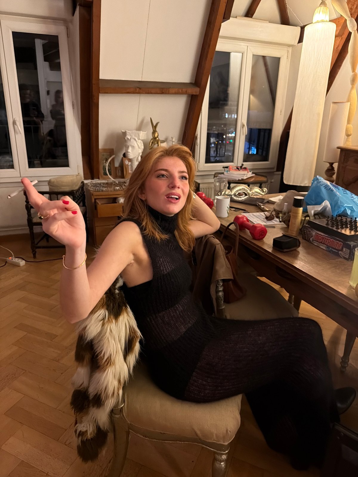 Woman in eclectic Paris room captured in evening scene