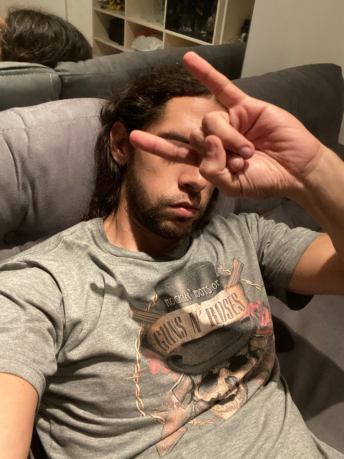 Person makes peace sign while relaxing on couch in Buenos Aires