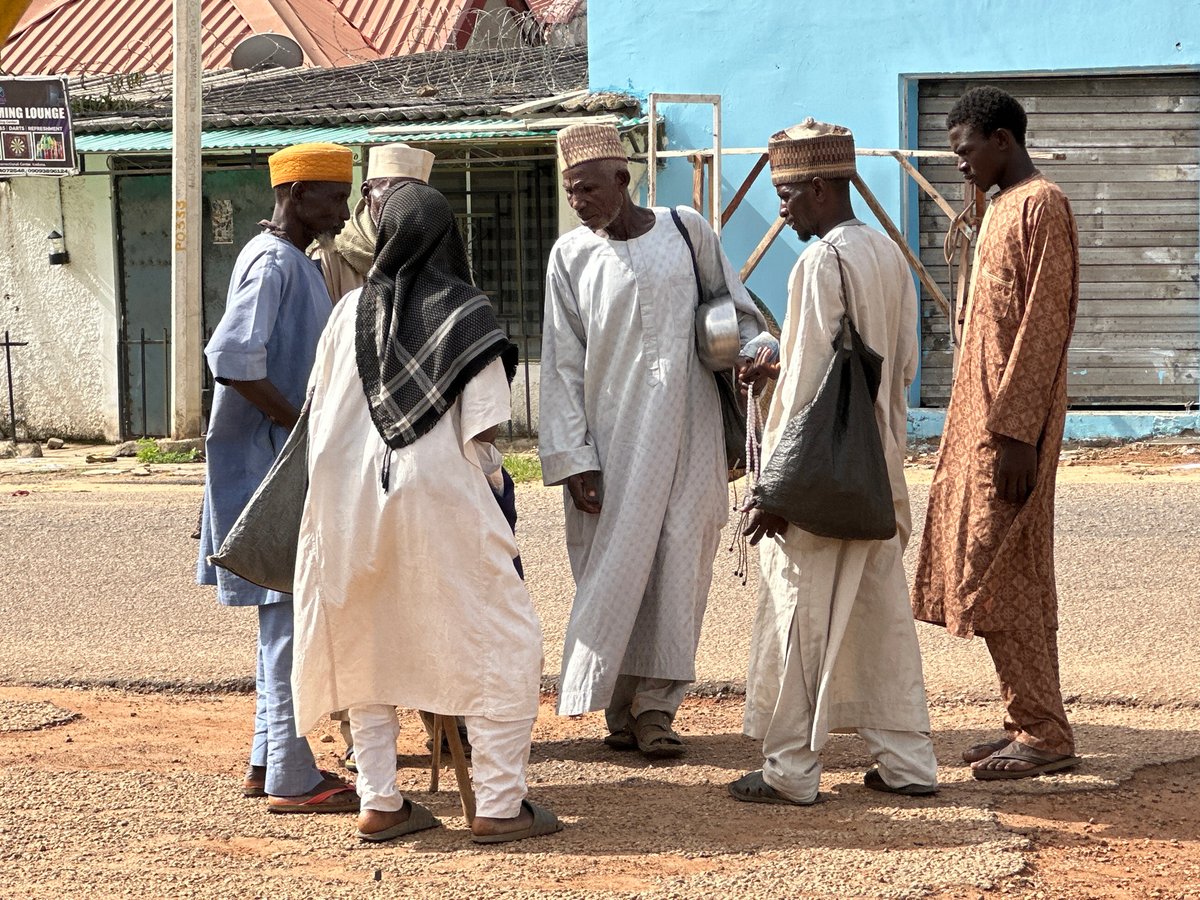 Men in traditional dress gather on Kaduna street