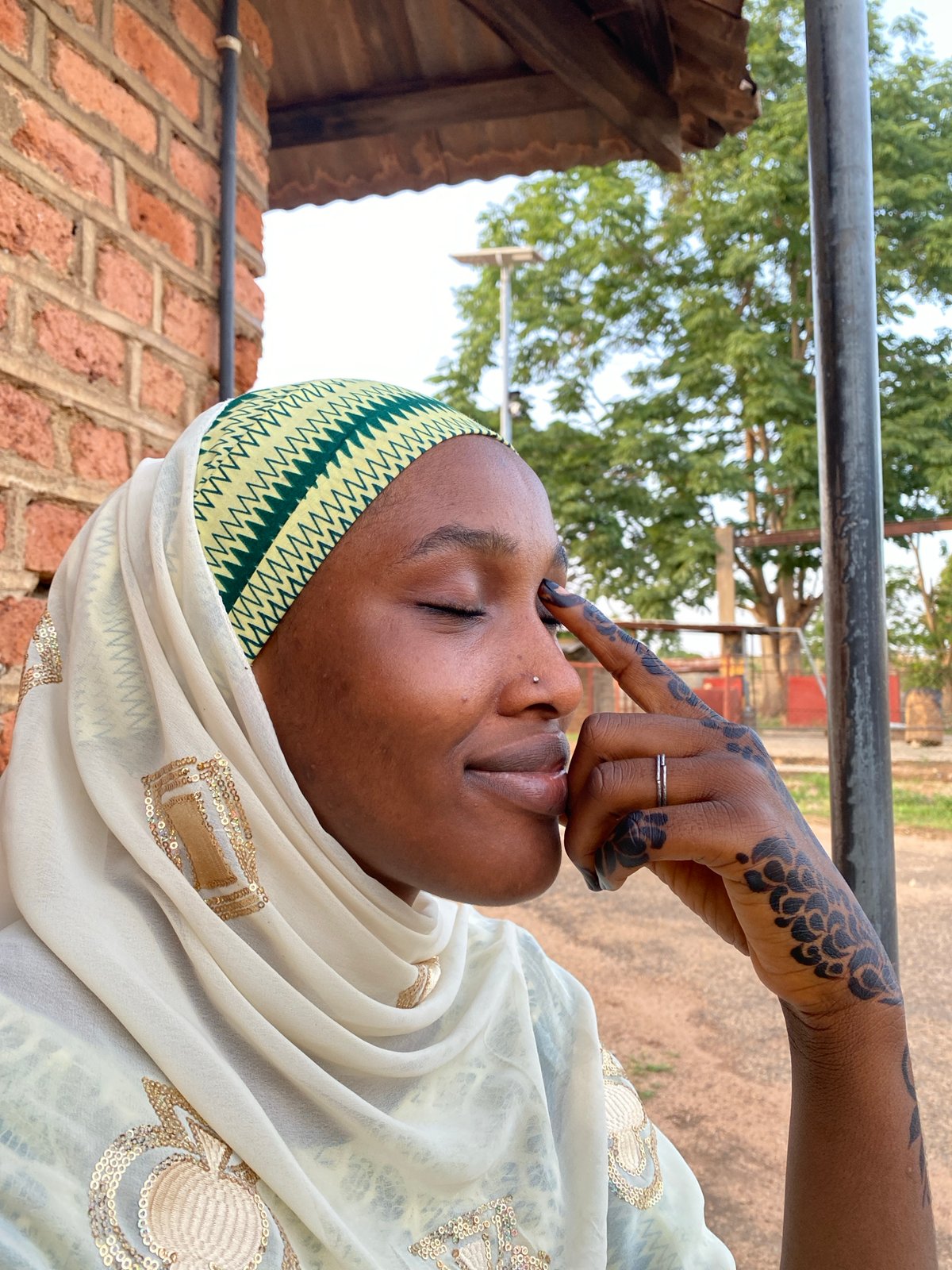 Woman in traditional dress photographed near brick building in Vom