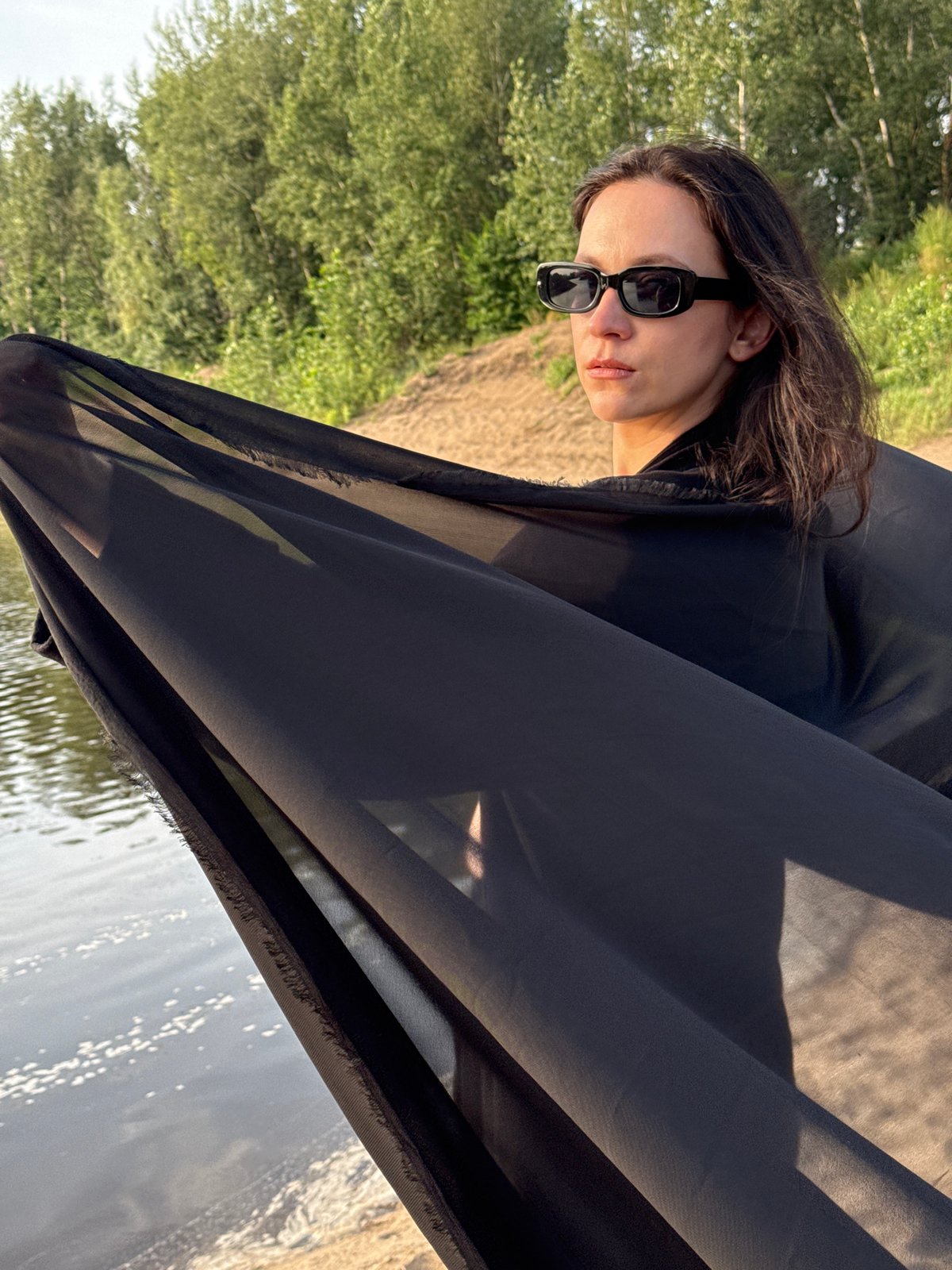Black fabric, water's edge, midday sun in rural Russia