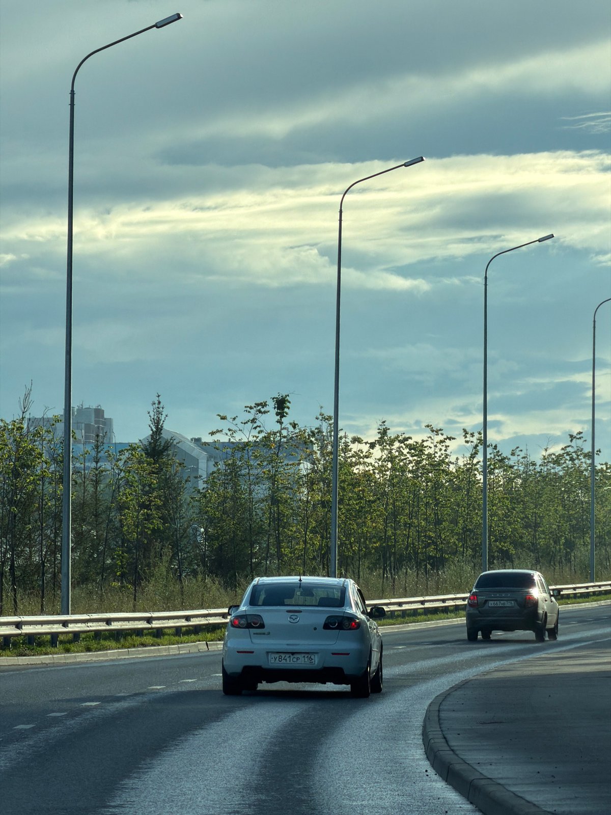 White Mazda 3 navigates wet Kazan highways on a cloudy afternoon