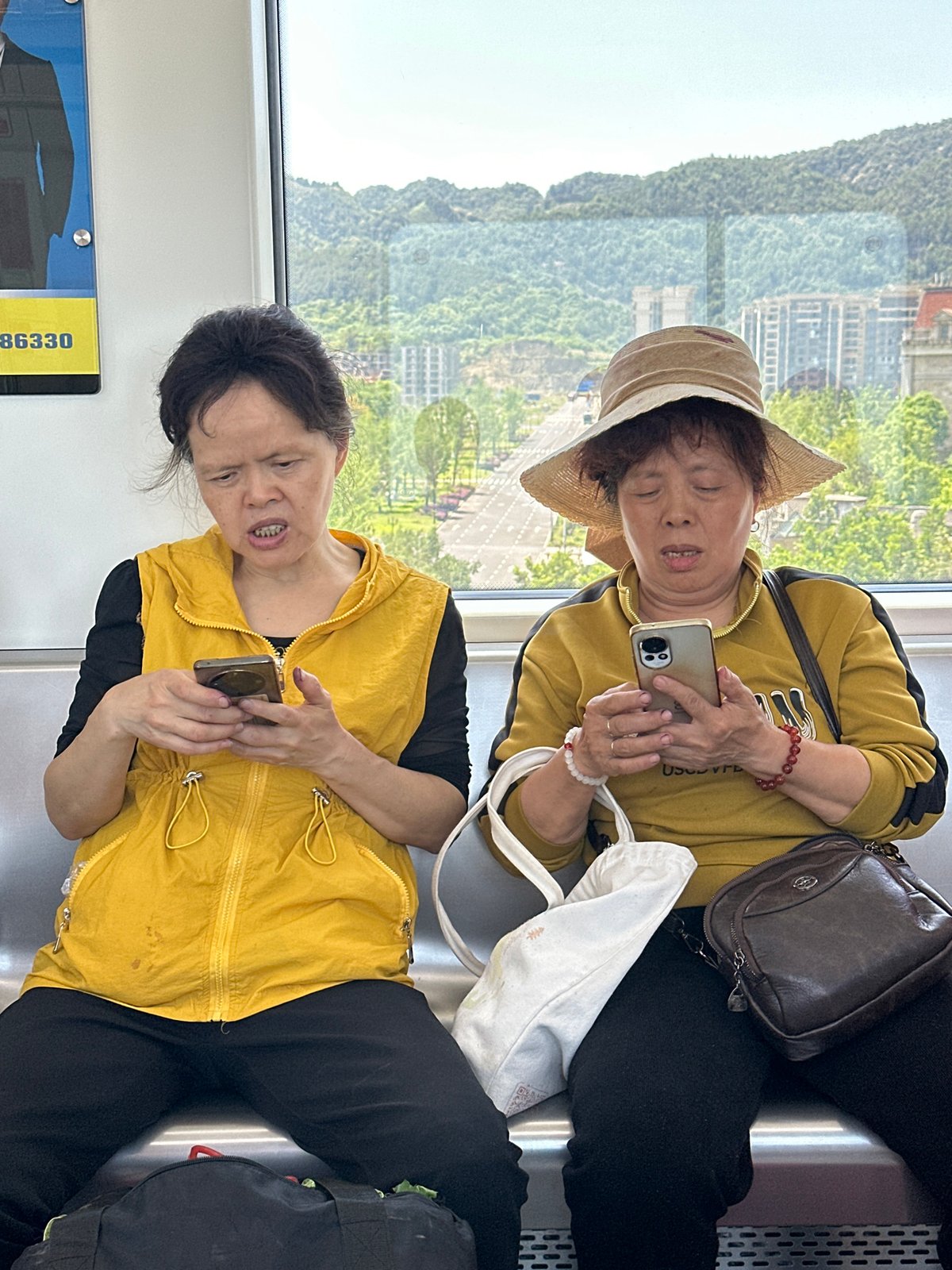 Two women use phones on public transport in Shuangfu