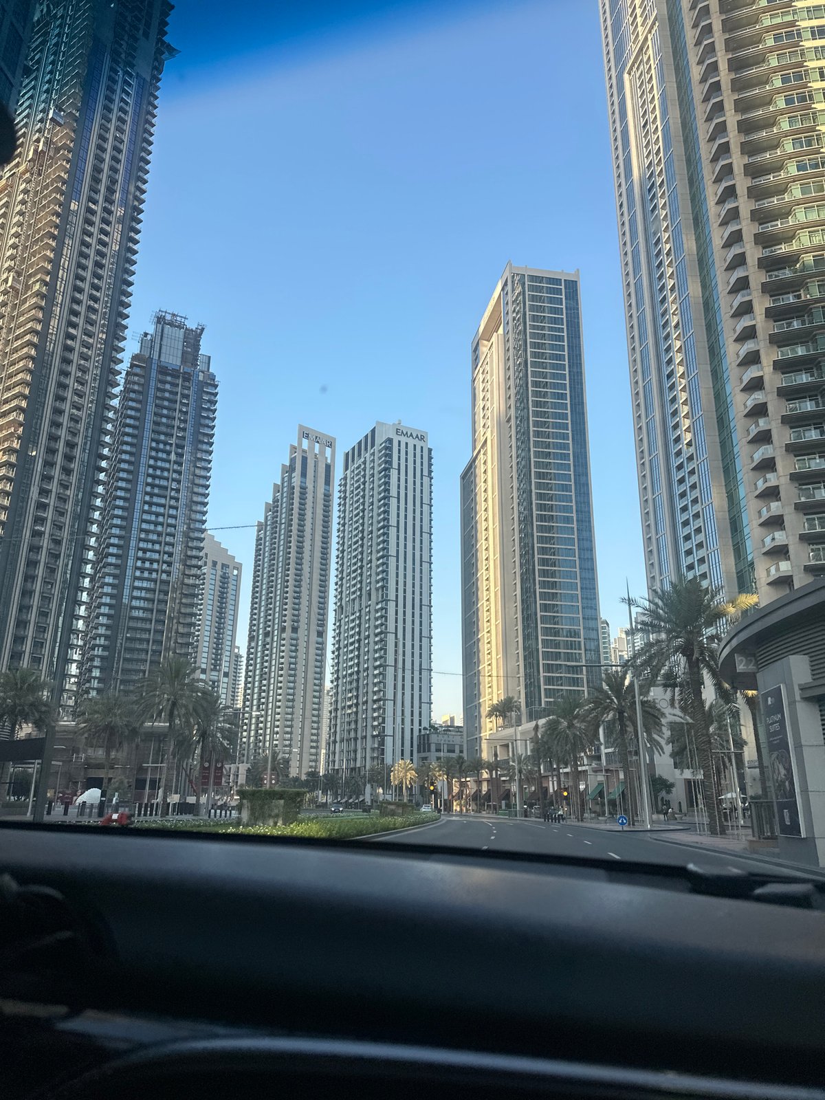 Street-level drive past Dubai's high-rise skyline