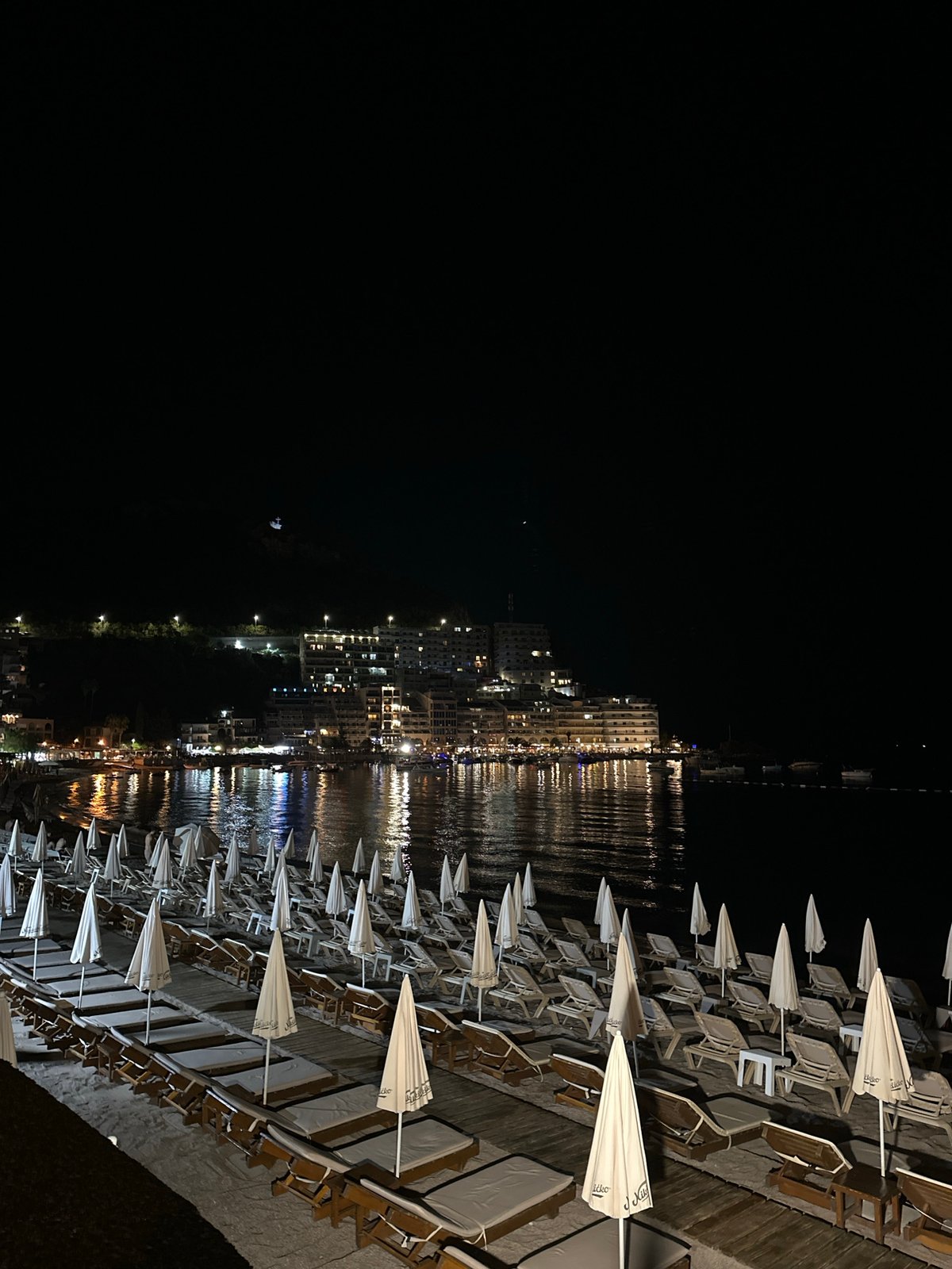 Rafailovići beach at night, town lights on the water