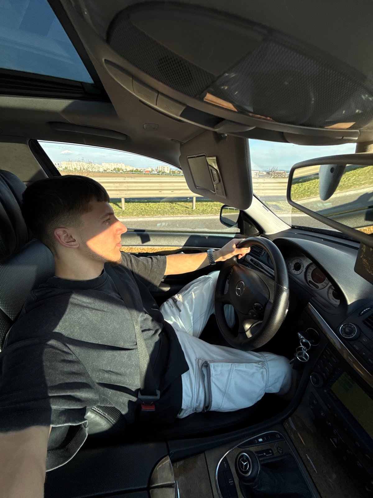 Driver reclines with feet on dashboard in Sofia Mercedes