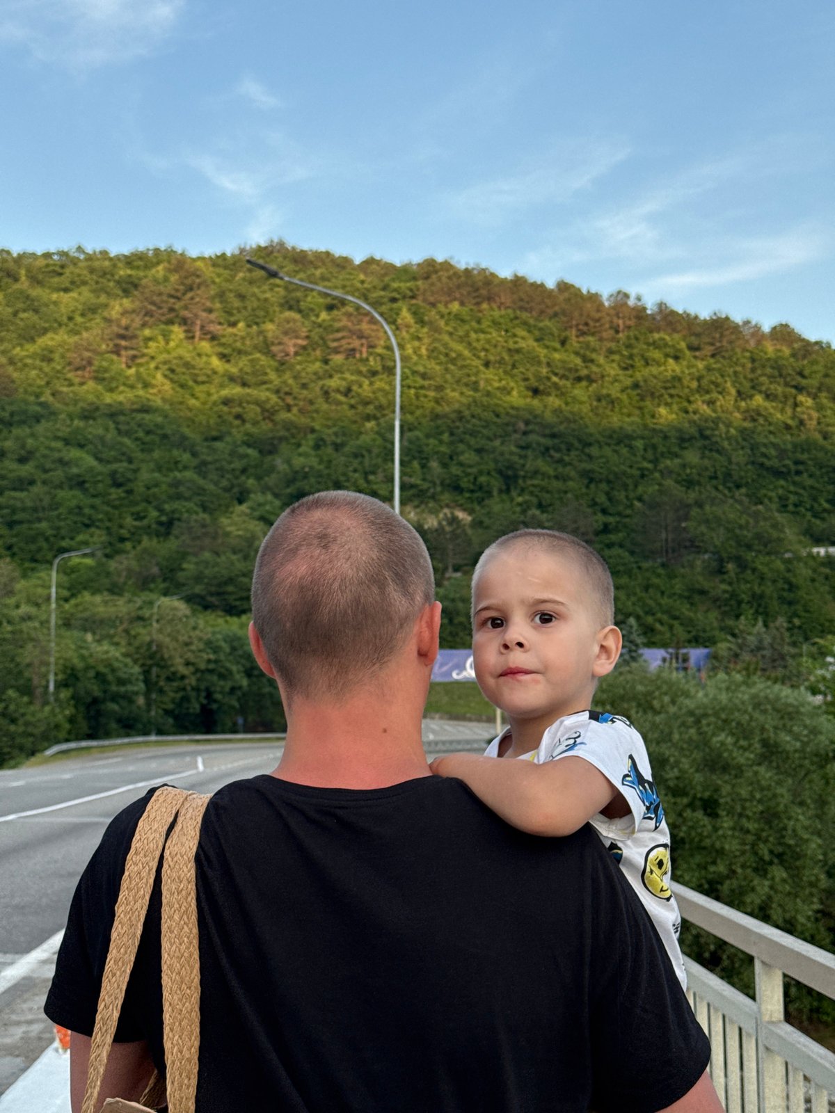 Father carries child on bridge in Nebug, Russia