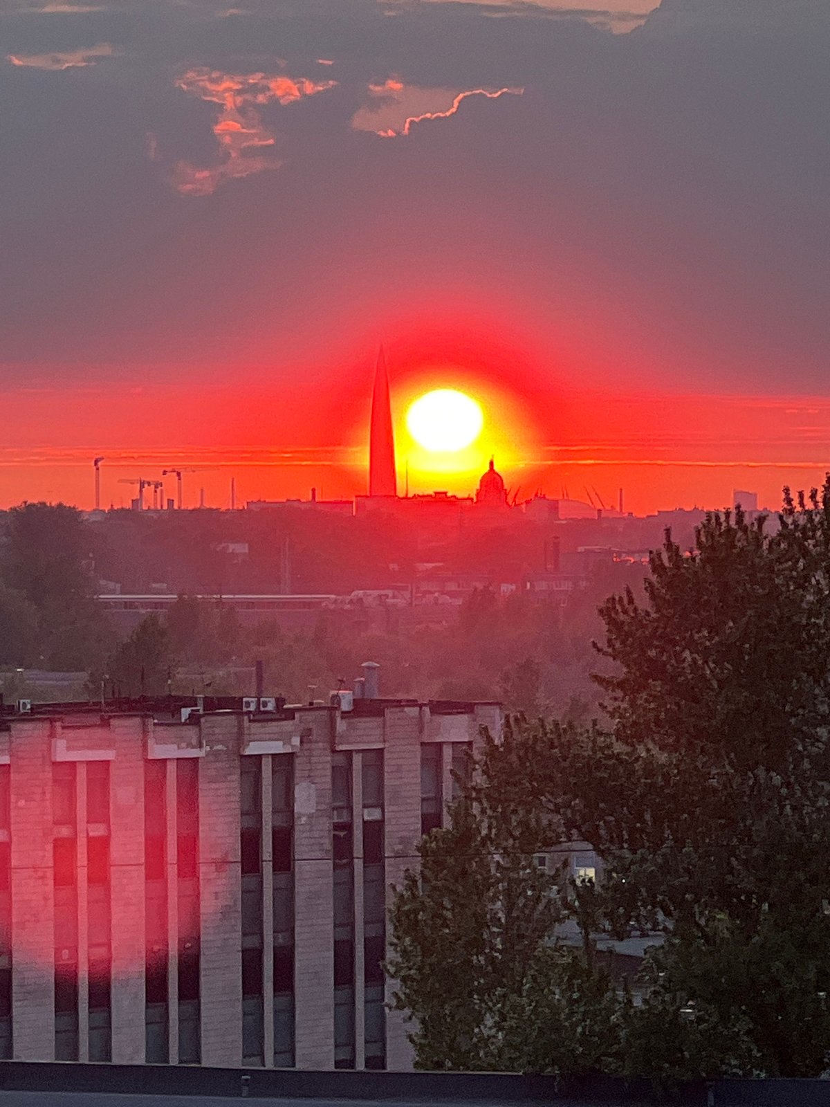Vibrant red sunset observed over Saint Petersburg cityscape