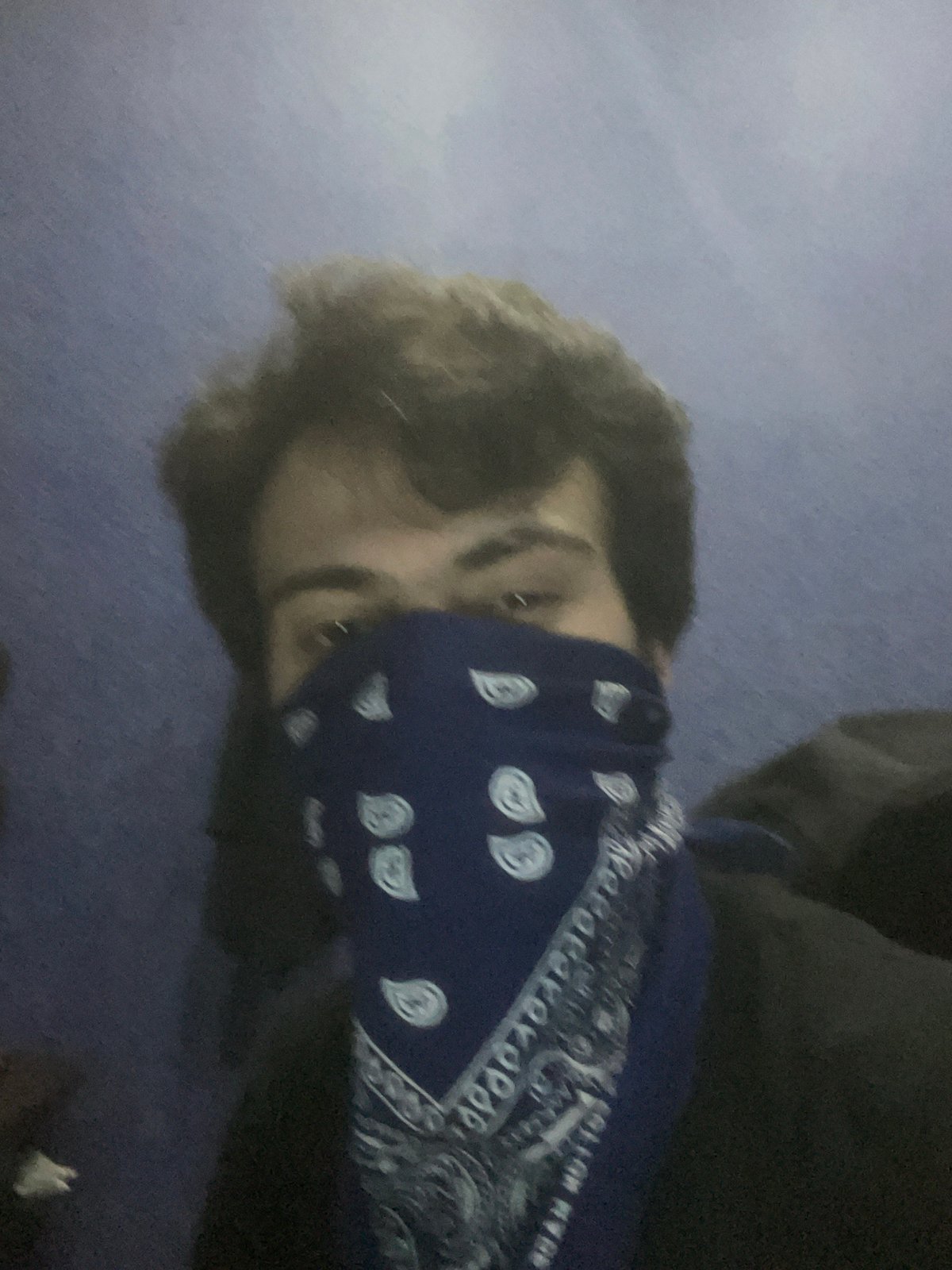 Young man documents bandana selfie session in Tbilisi room