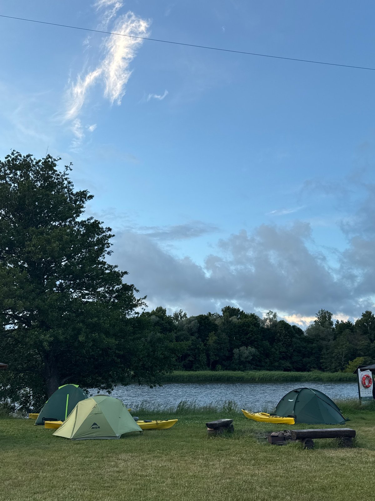 Camping and kite flying by the Gauja River at dusk