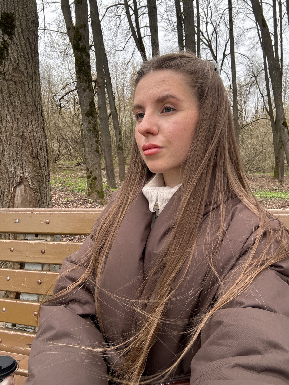 Woman walks dog during morning coffee break in Klin park