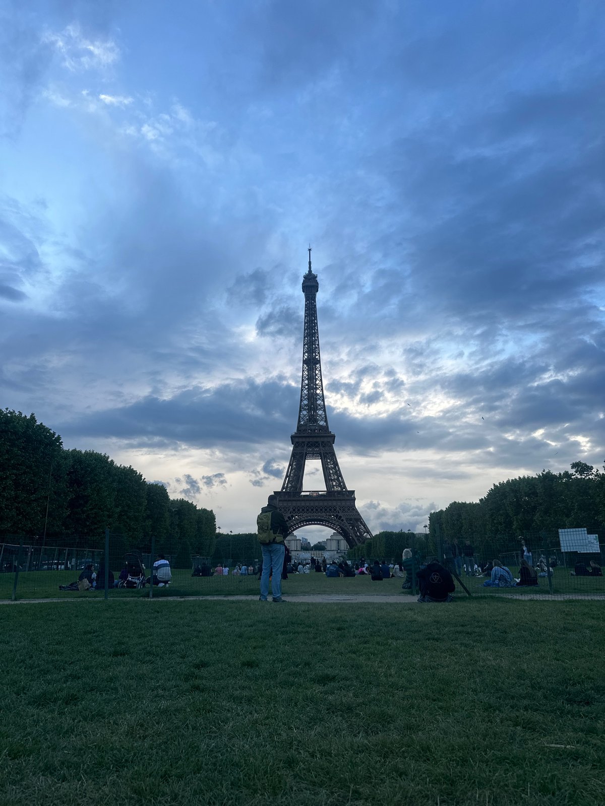 Person walks across Eiffel Tower lawn in Paris