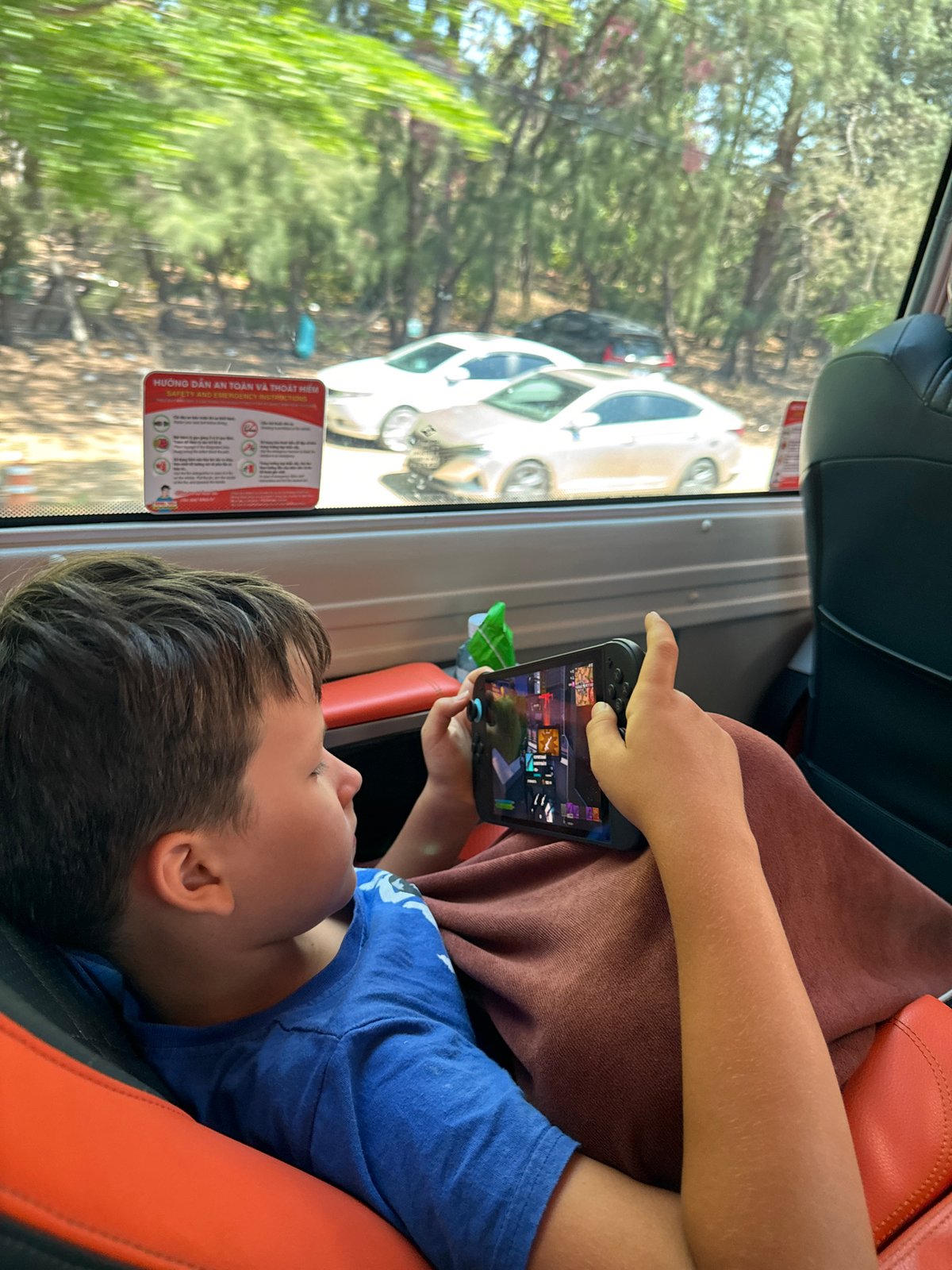 Child plays mobile game during vehicle journey in Vietnam