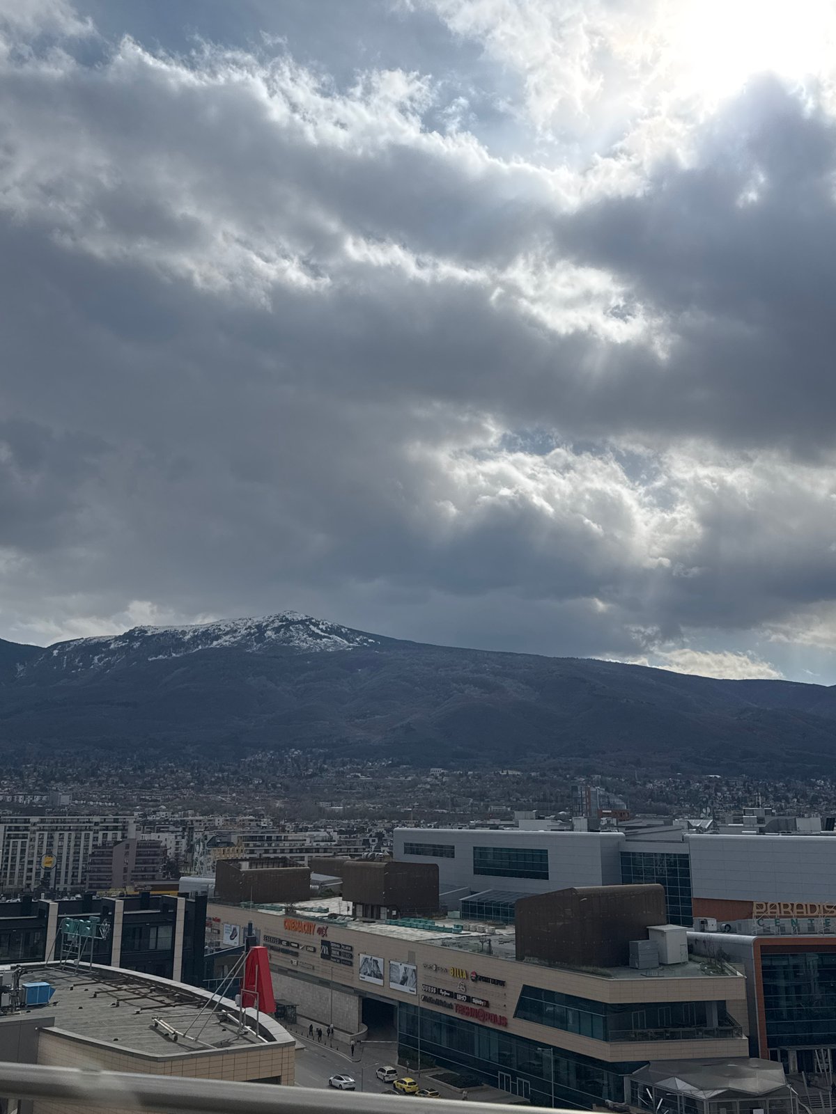 Man takes rooftop selfies overlooking Sofia cityscape