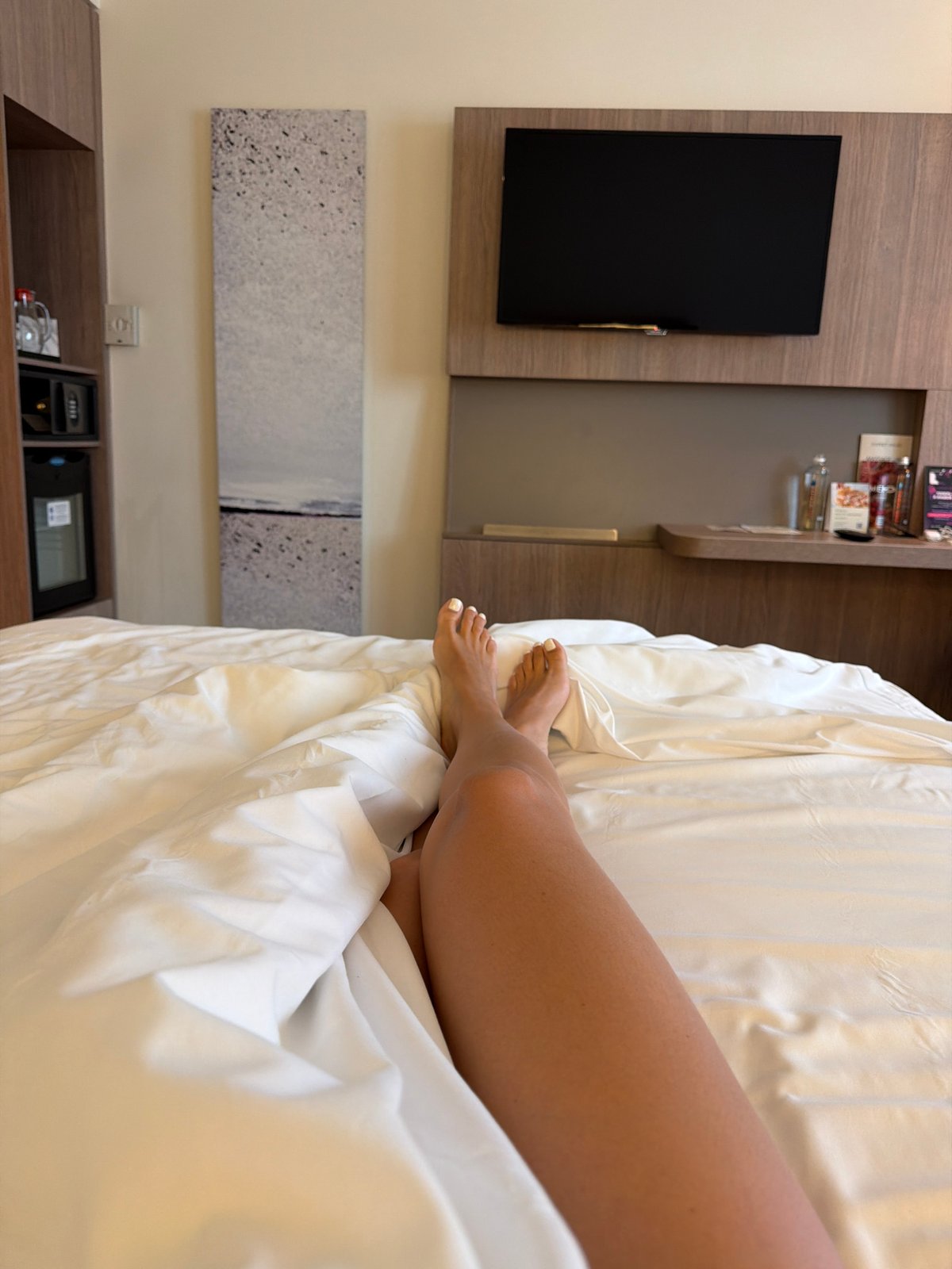 Person relaxes in Moscow hotel room, shows fresh manicure