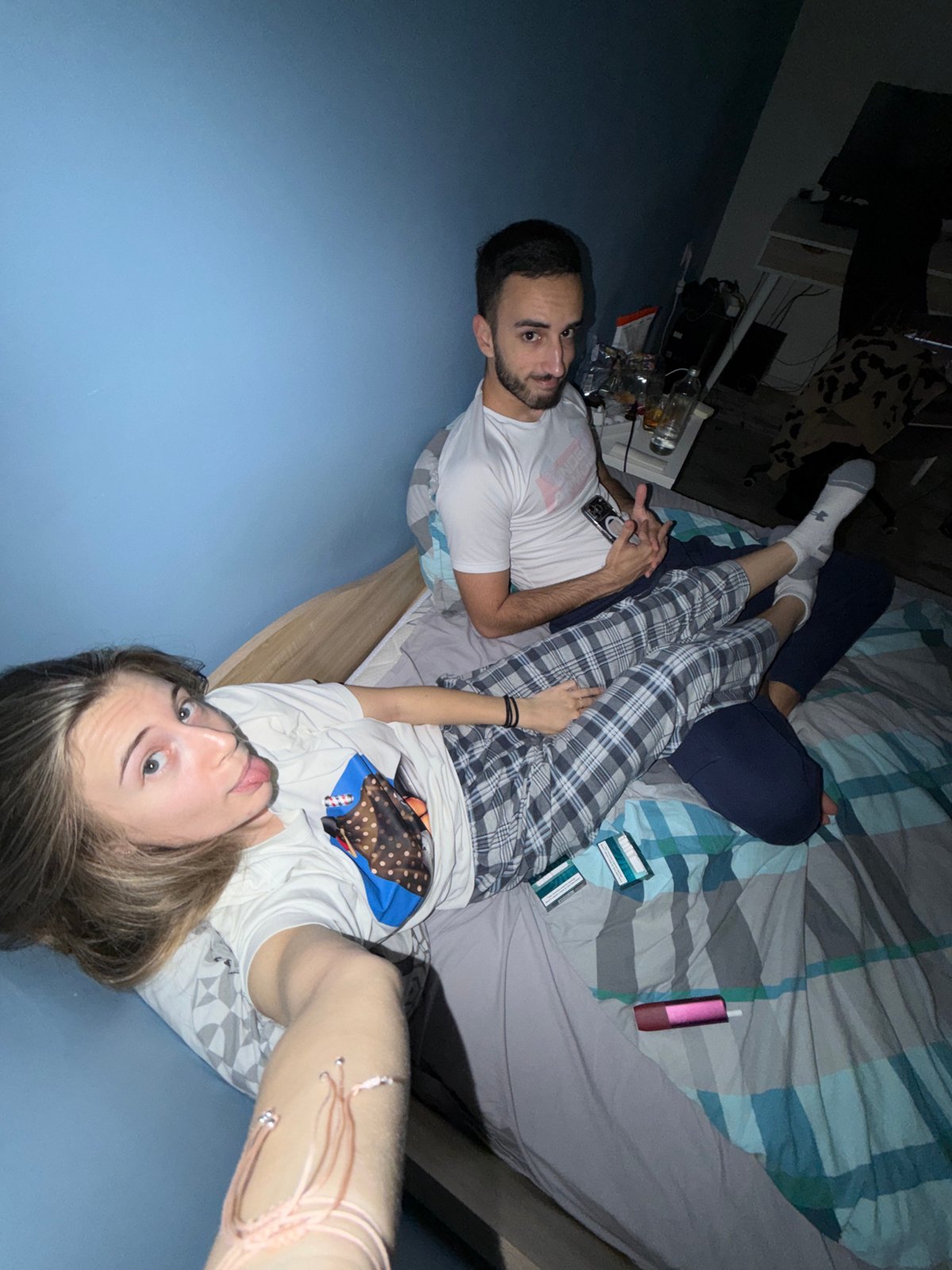 Two people relax on bed with phone in Plovdiv