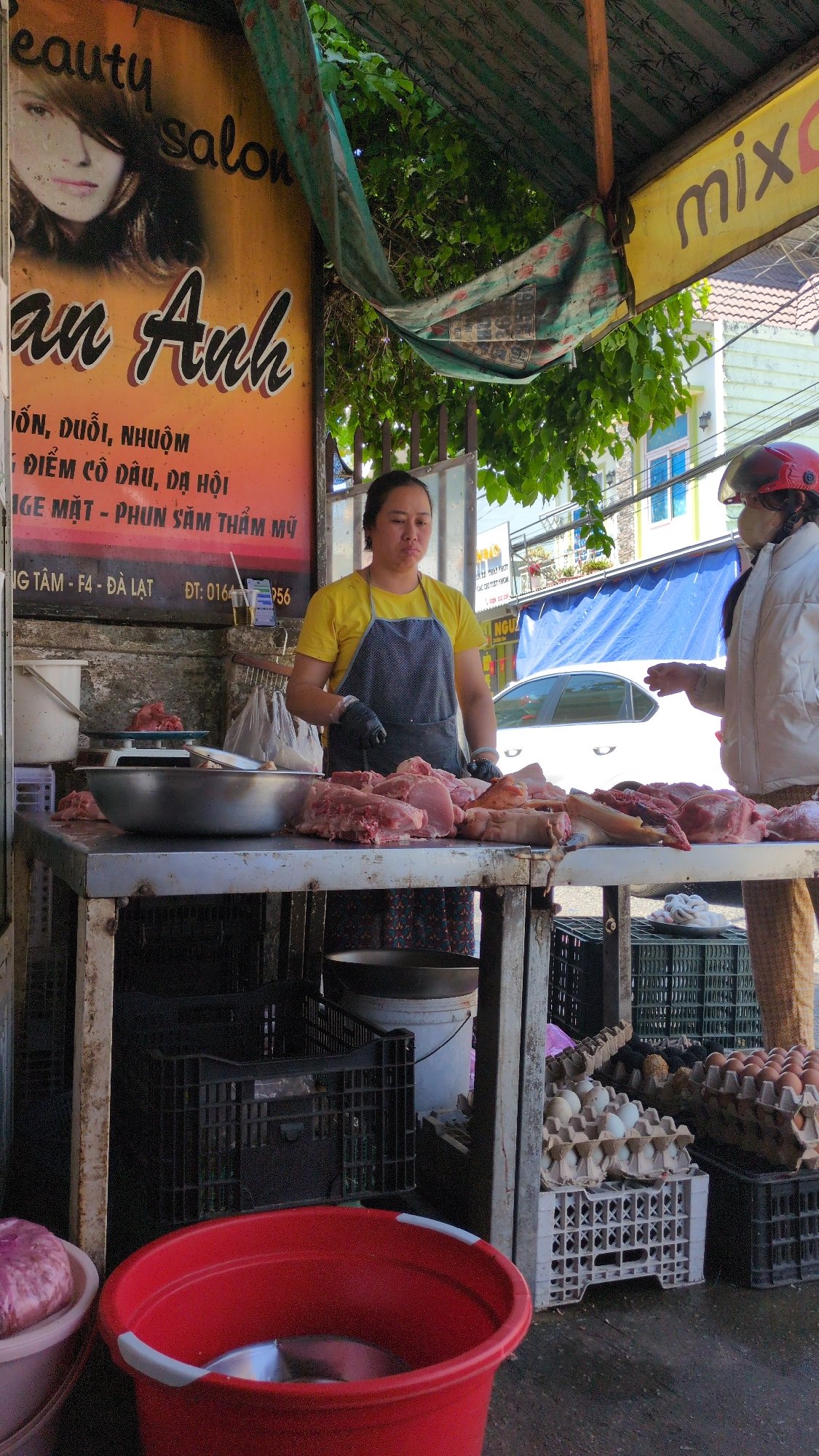 Early morning street vendor operates meat stall in Da Lat