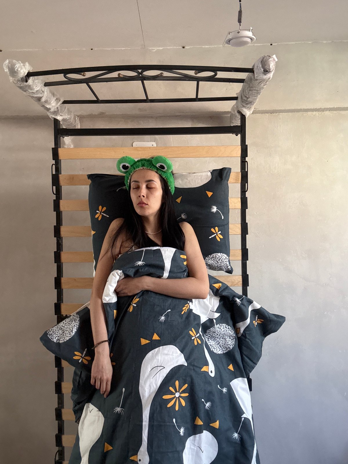 Woman in frog headband sleeps, poses in Votkinsk bedroom
