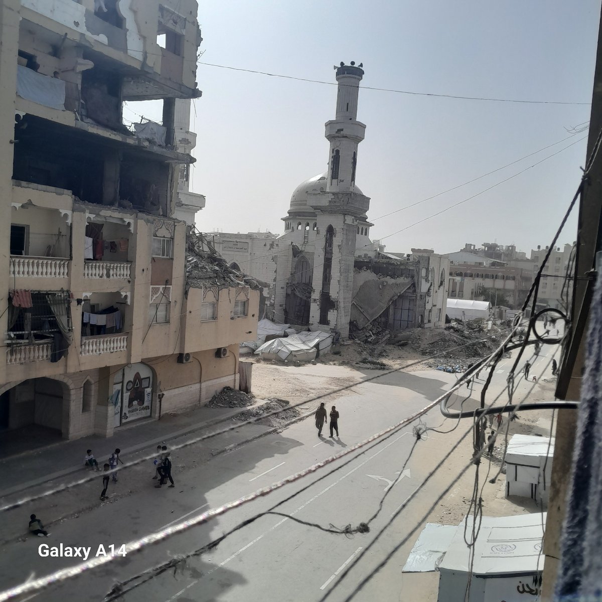 Urban street scenes show temporary arrangements amid damaged buildings
