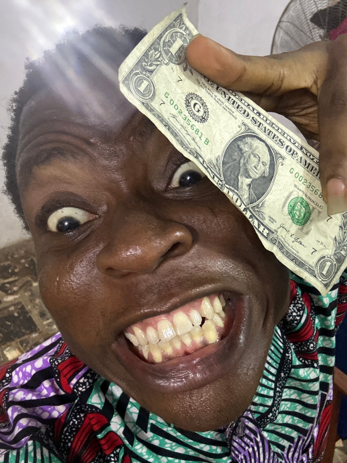 Person records playful selfie videos with dollar bill indoors