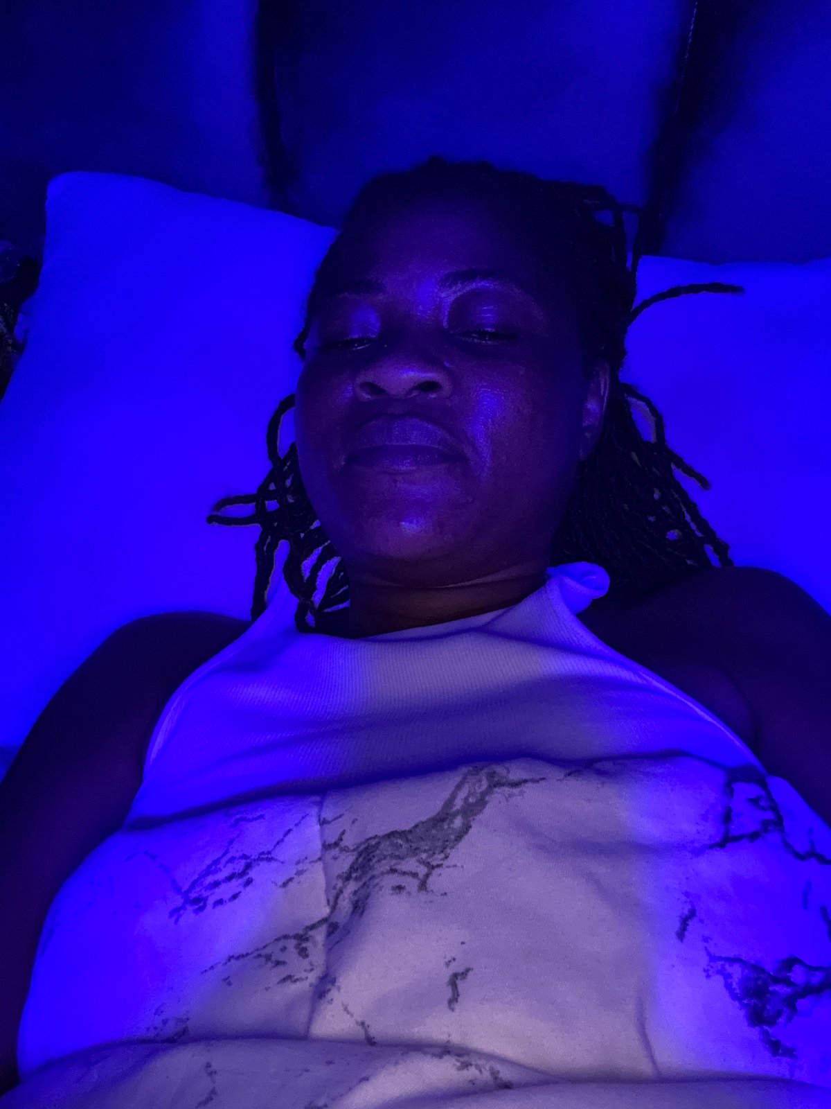 Blue-lit bedroom scene in Ajara, Nigeria