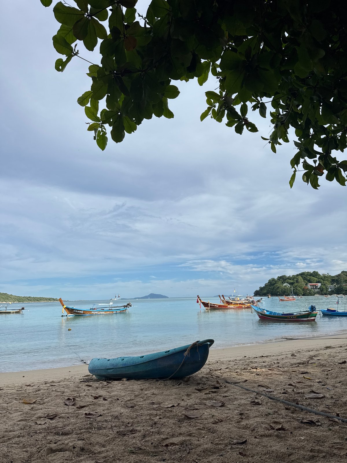 Kayaks on Rawai beach, green mangoes at a nearby stand
