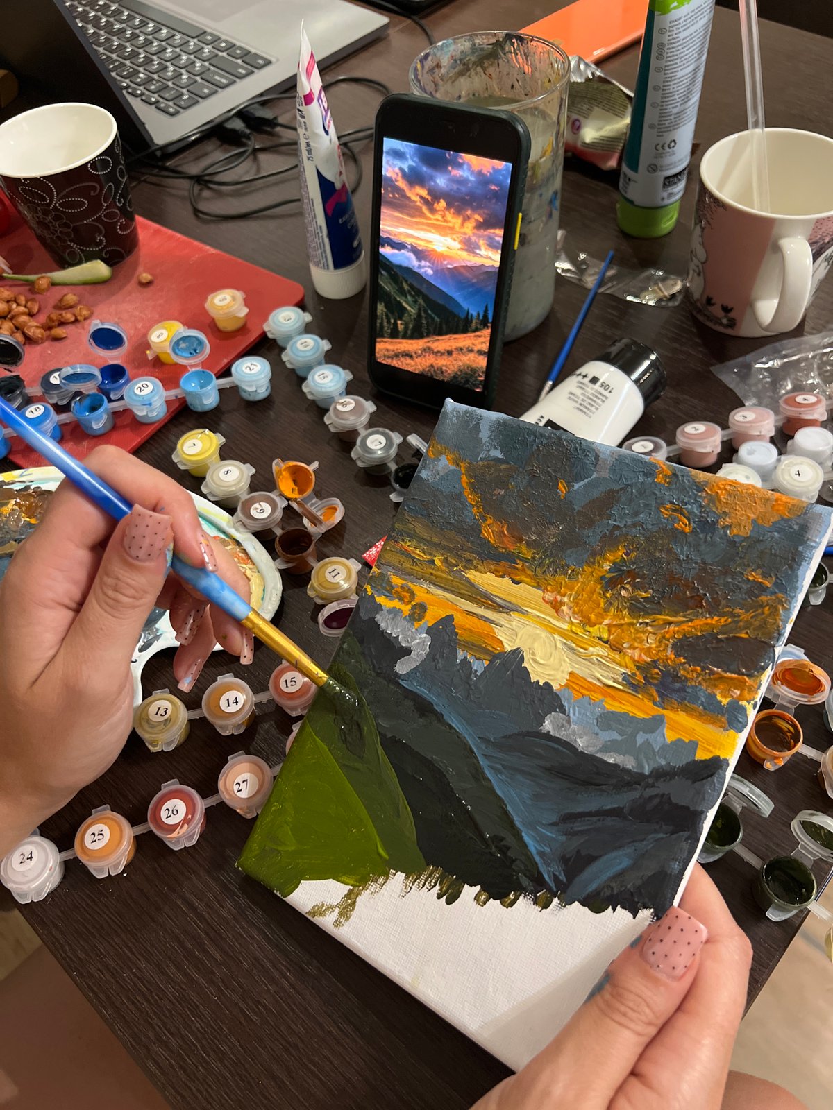 Woman paints mountain sunset landscape in Podgorica
