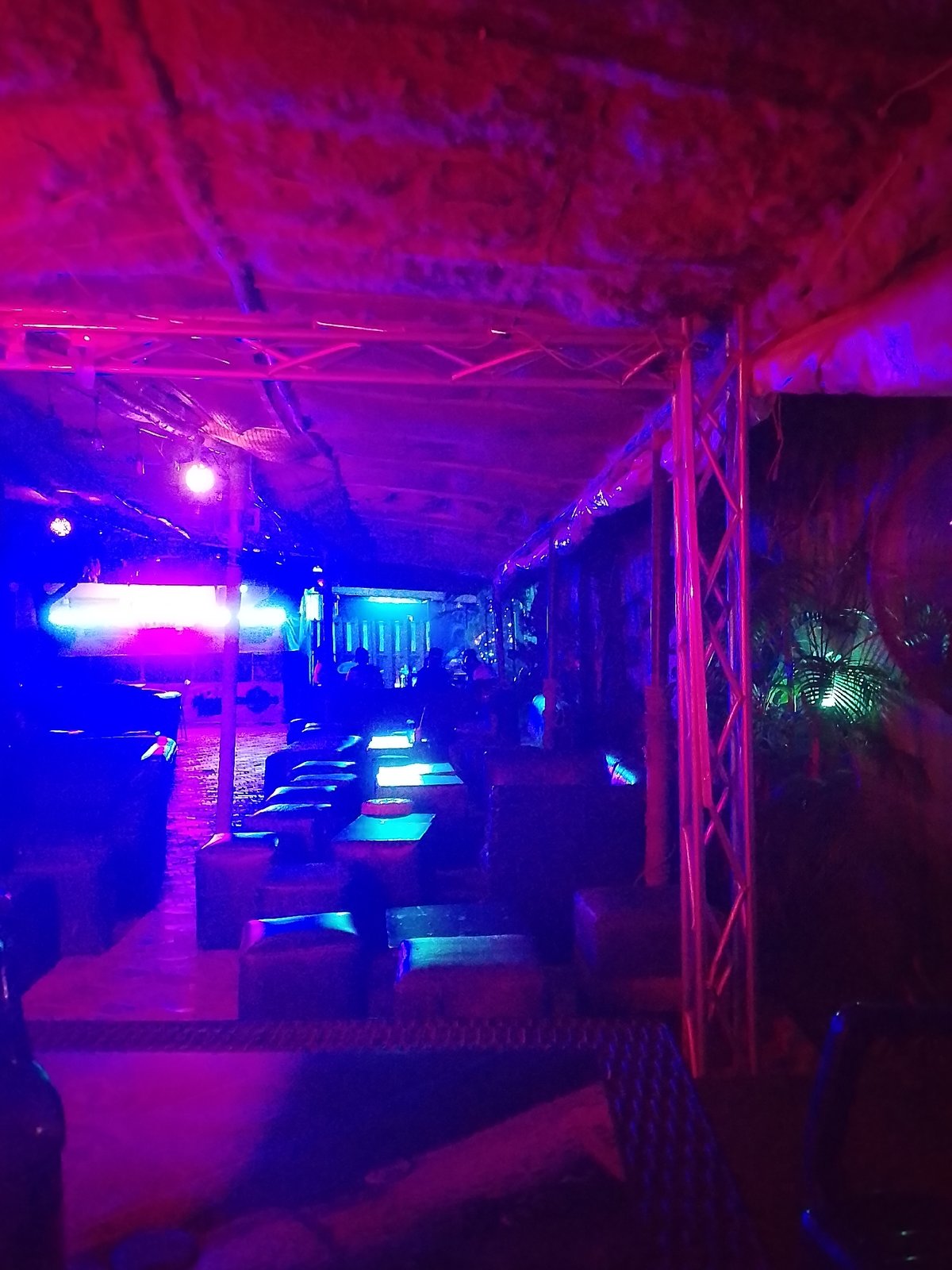 Two people sit at table in nighttime bar venue
