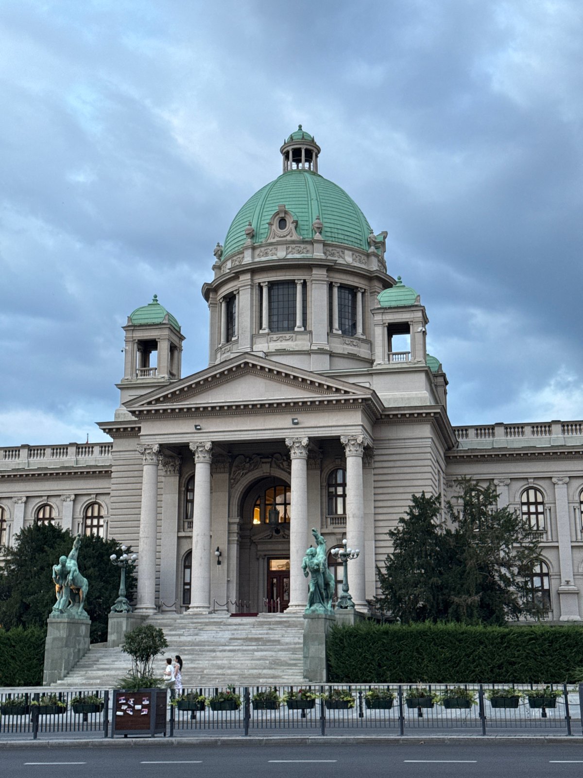 Street-level pause near a grand domed building in Belgrade