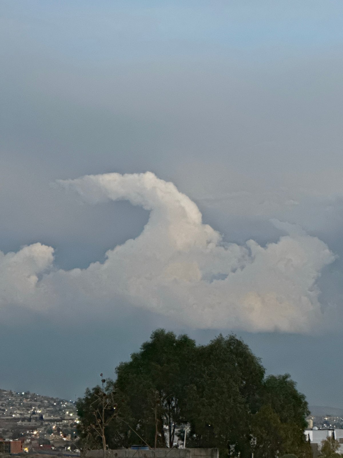 Cloudy night sky photographed over hillside community in Puebla