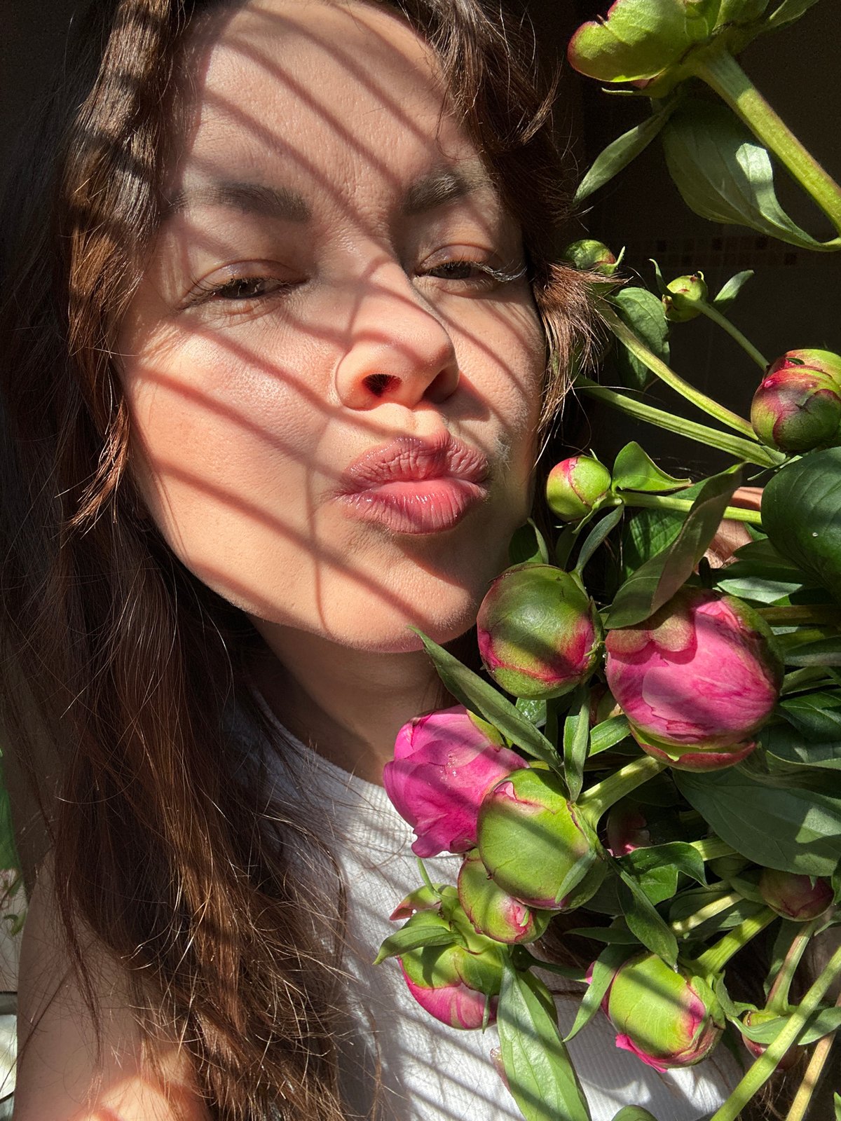 Woman enjoys morning breakfast with peonies in Chaikovsky, Russia