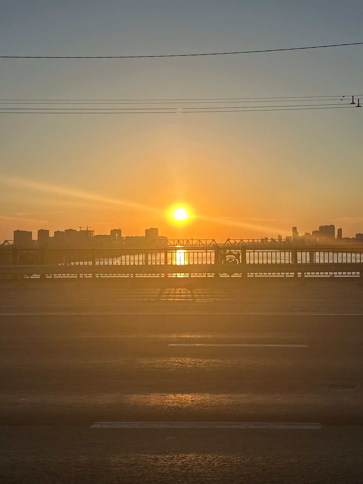 Novosibirsk bridge at golden hour, city skyline glowing