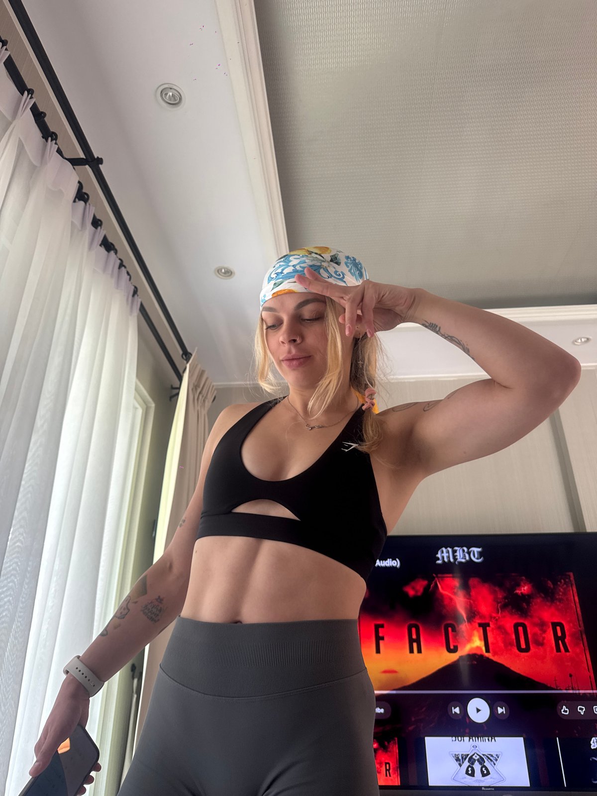 Woman takes selfies in athletic wear in Chalong, Thailand