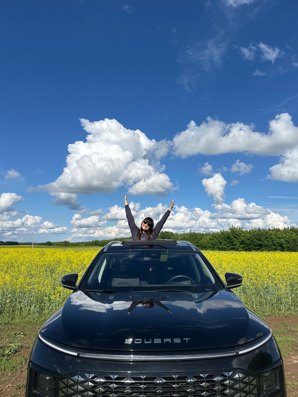 Woman celebrates through open vehicle roof in Kon'ki, Russia