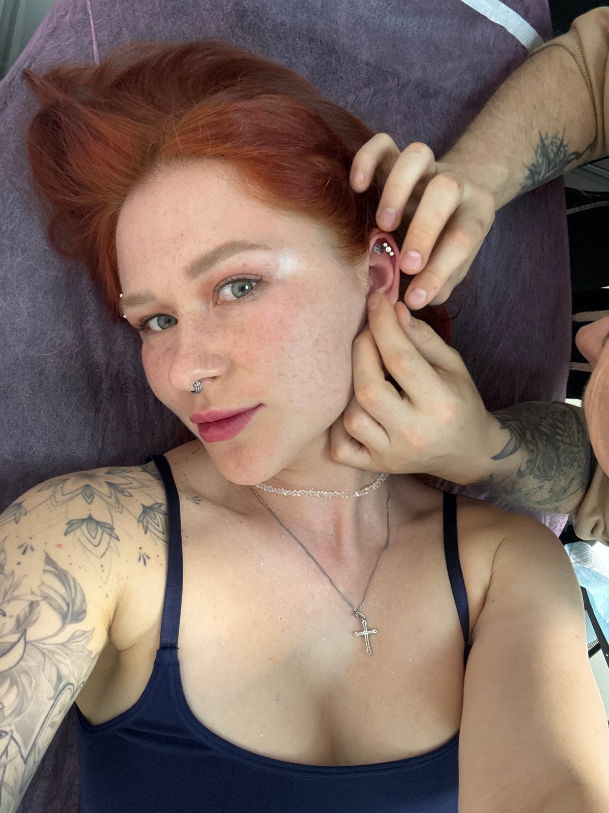 Woman receives ear piercing at Rostov-on-Don tattoo parlor