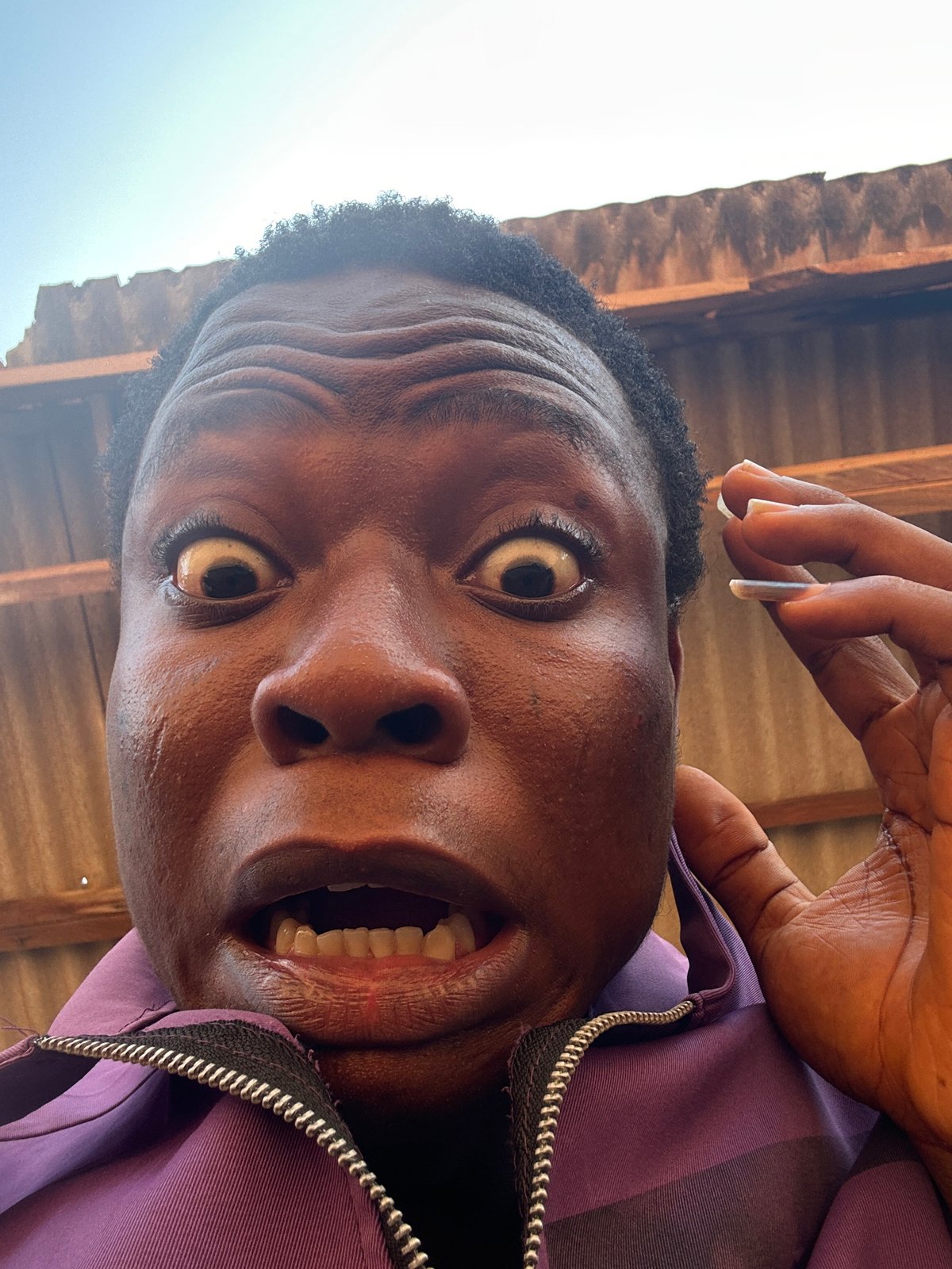 Man takes series of expressive selfies in purple jacket