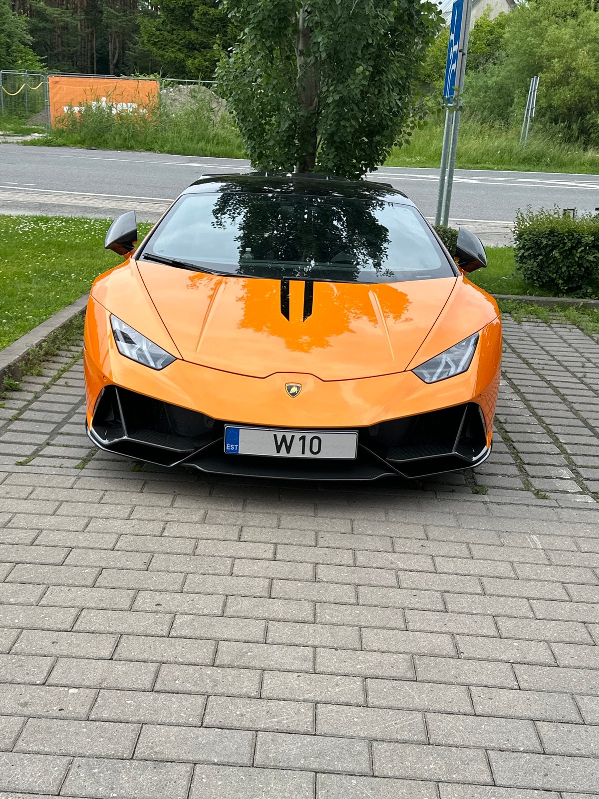 Orange Lamborghini Huracán parked on pavers in Tallinn
